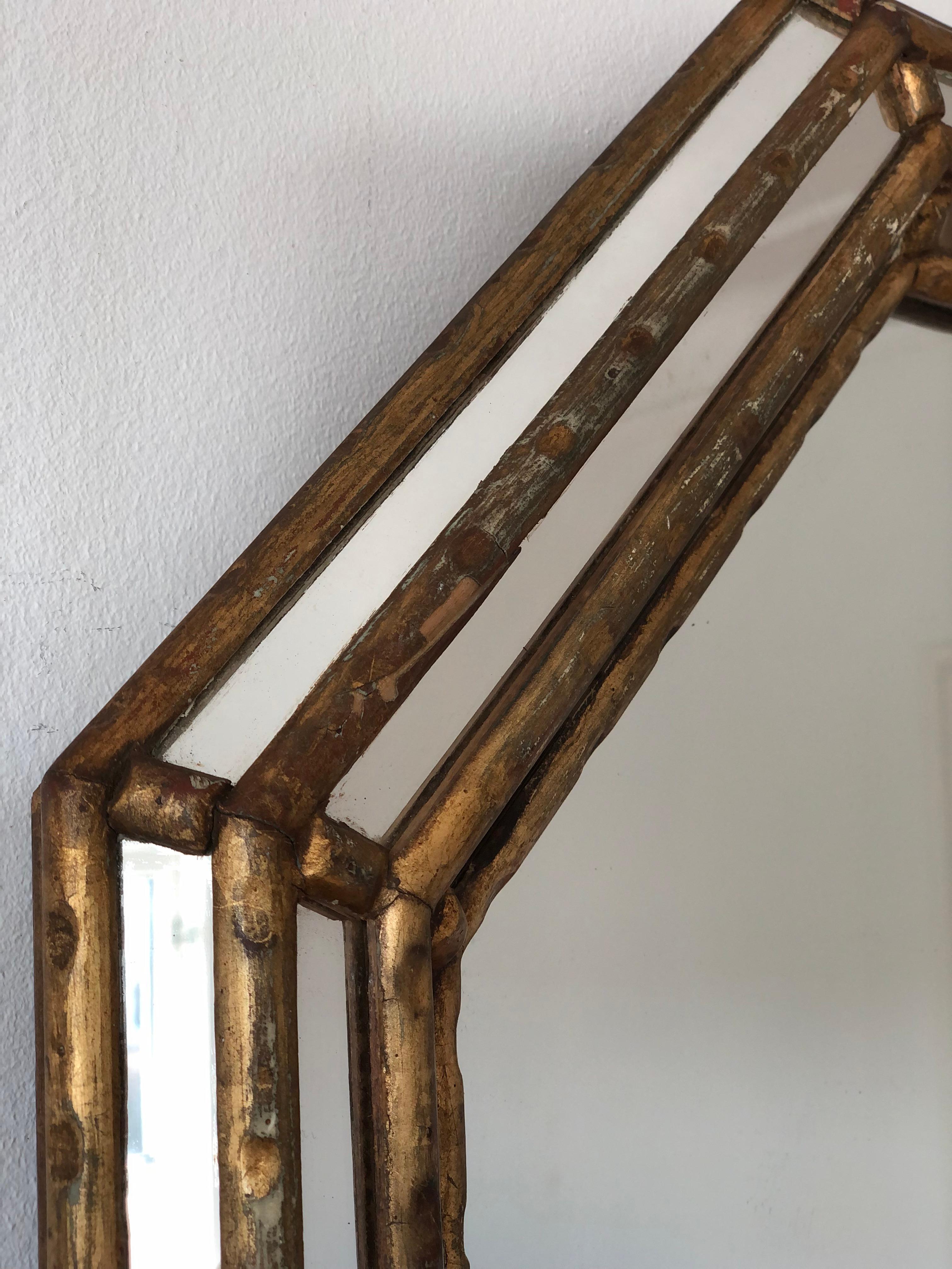 Este espejo octogonal vintage de LaBarge, fabricado en Italia en la década de 1970, tiene un marco dorado de imitación de bambú. El marco artesanal está adornado con pequeños espejos a lo largo de los bordes exterior, interior y central, que añaden