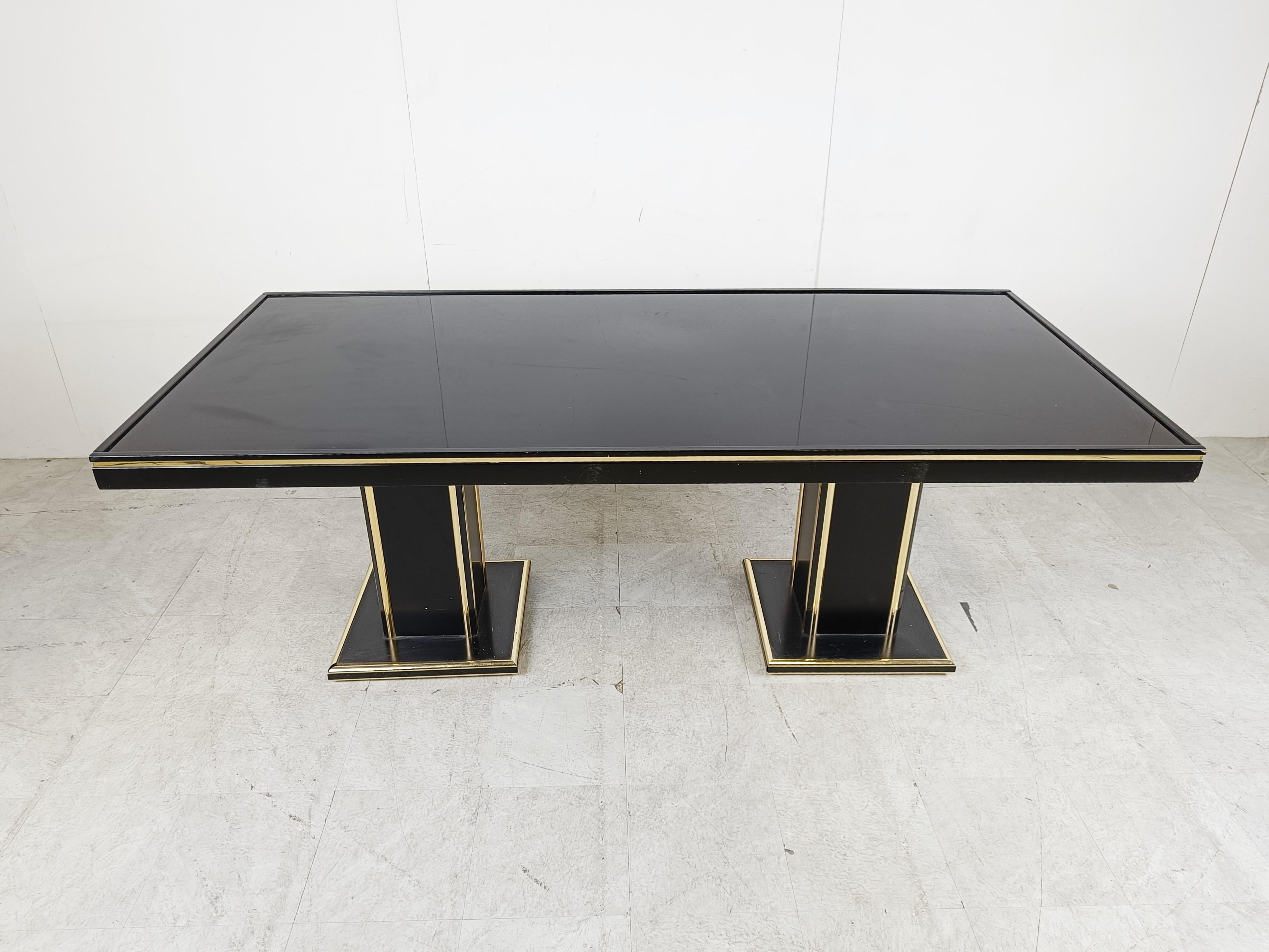 Vintage seventies glam dining table made from black lacquered wood and brass.

The black lacquer with golden finish gives a luxurious appeal. 

Probably french made in the style of Pierre Vandel. 

Good overall condition with normal age related