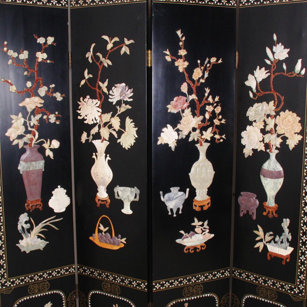 An excellent quality four panel black lacquered screen featuring vases of flowers rendered in carved semi-precious hard stone, jade and mother of pearl.