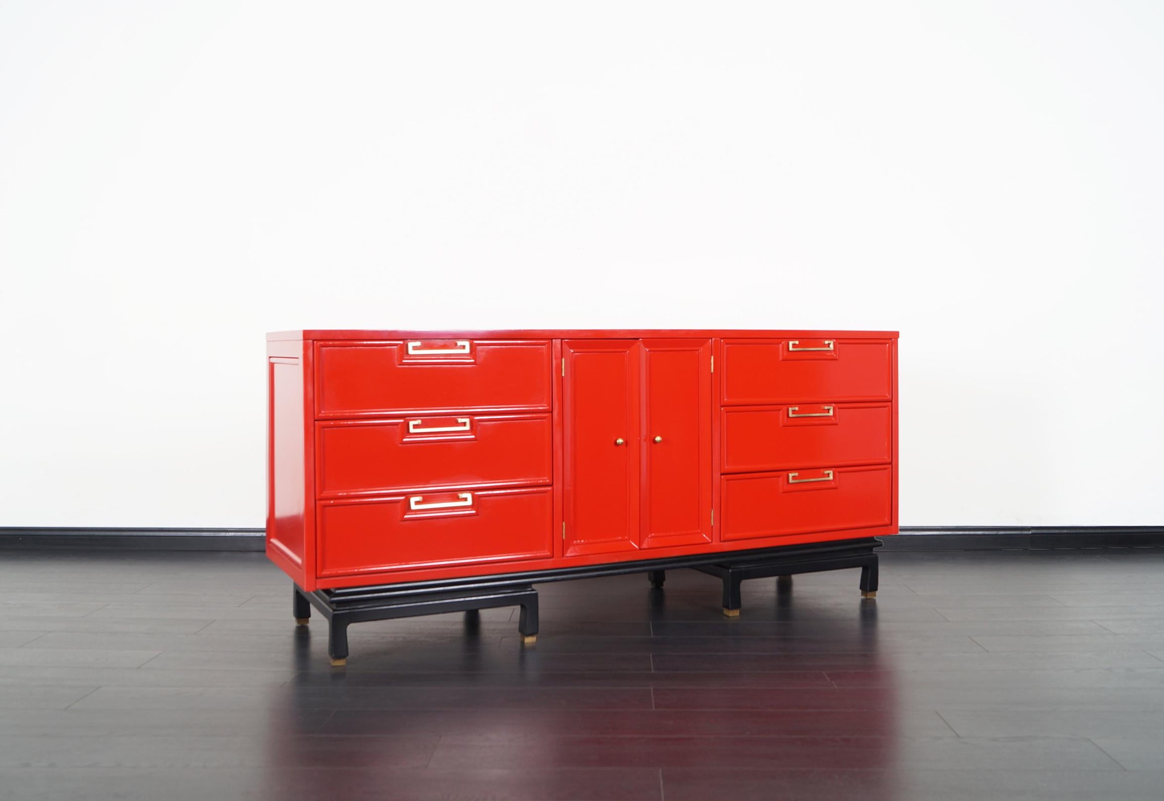 A beautiful vintage lacquered dresser designed and manufactured by American of Martinsville in the United States, circa 1950s. This elegant dresser has been professionally restored in Candy Red lacquer finish. Features a total of nine dovetailed