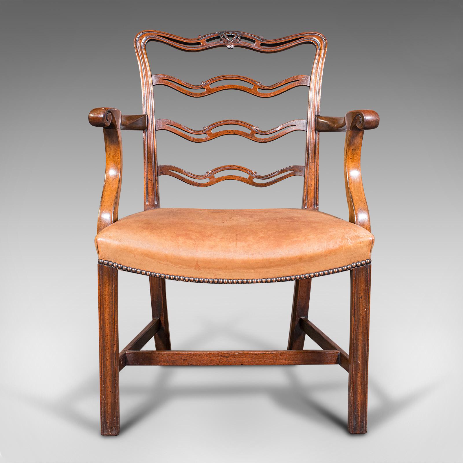 This is a vintage ladder back study chair. An Irish, mahogany elbow seat or carver, dating to the Art Deco period, circa 1940.

Striking chair in Irish Chippendale revival taste
Of generously wide profile for comfortable modern use
Displaying a