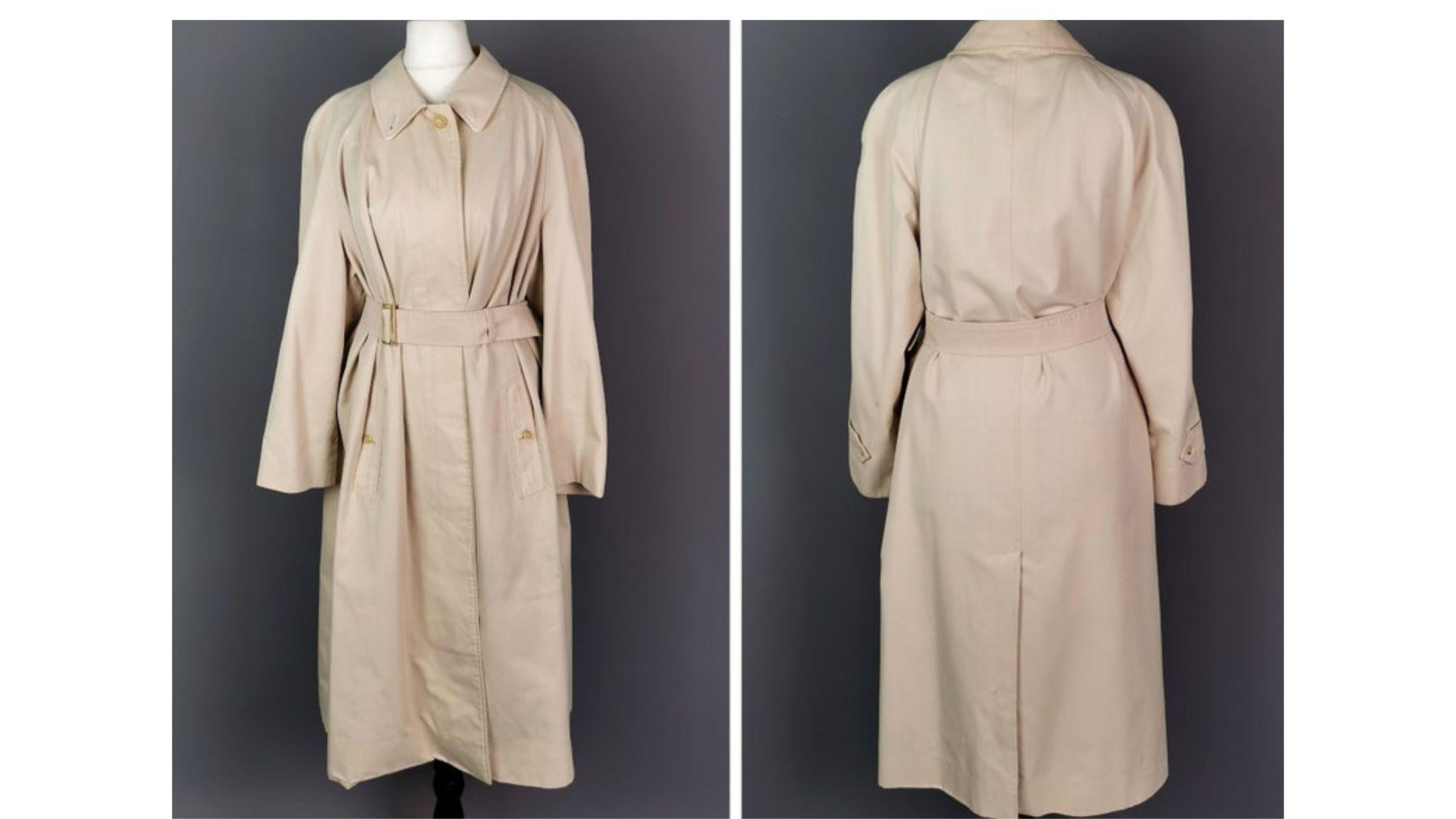 A stunning and iconic vintage Burberry trench coat.

This is a ladies trench coat, light beige with a classic Burberry Nova check lining.

It fastens with a marbled plastic button fastening and comes with a separate waist belt.

Labelled Burberry