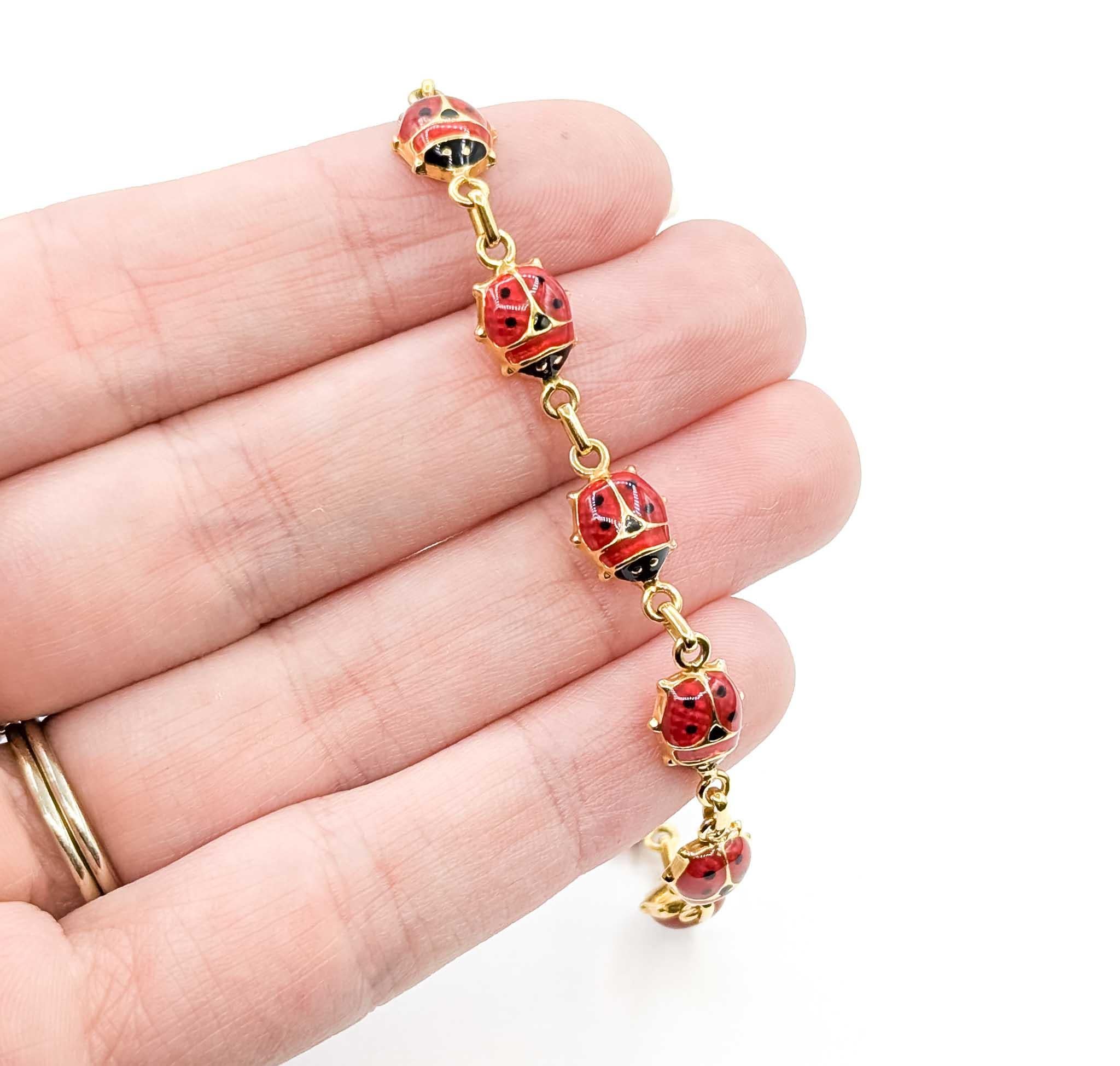Ce charmant bracelet vintage présente une série de coccinelles en émail rouge vif, chacune mesurant environ 8 mm, reliées entre elles par de l'or jaune 14k poli. Les coccinelles sont ornées de taches d'émail noir, ce qui ajoute un caractère