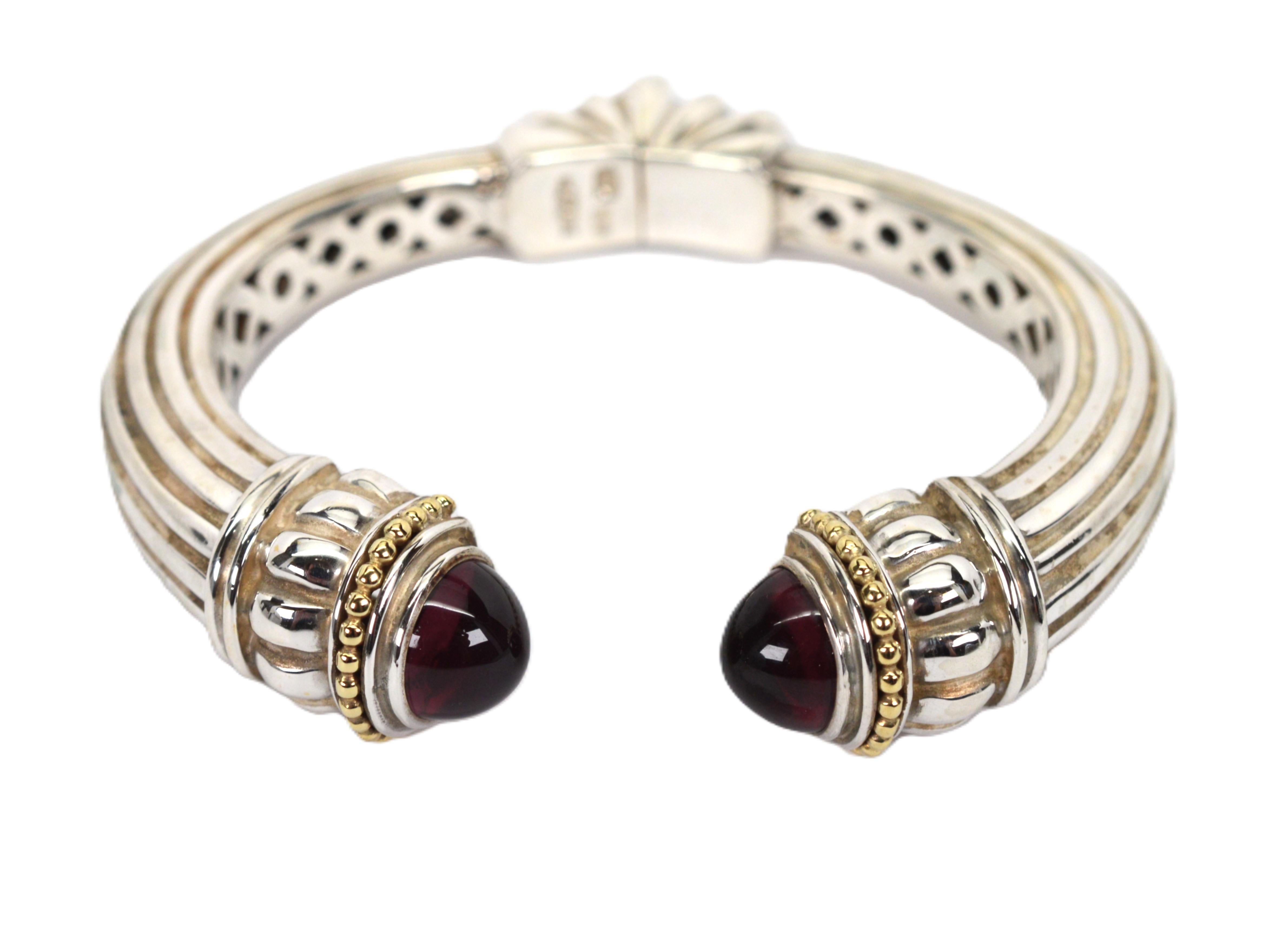 Vintage Lagos Cavier .925 Sterling Silver Cuff Bracelet with Natural Garnet Cabochons and 18K .750 Yellow Gold Accents. Overall measurement is 2-5/8 inch x .51 inch width. To determine fit , inside has a 6 inch circumference. Spring hinge opens to