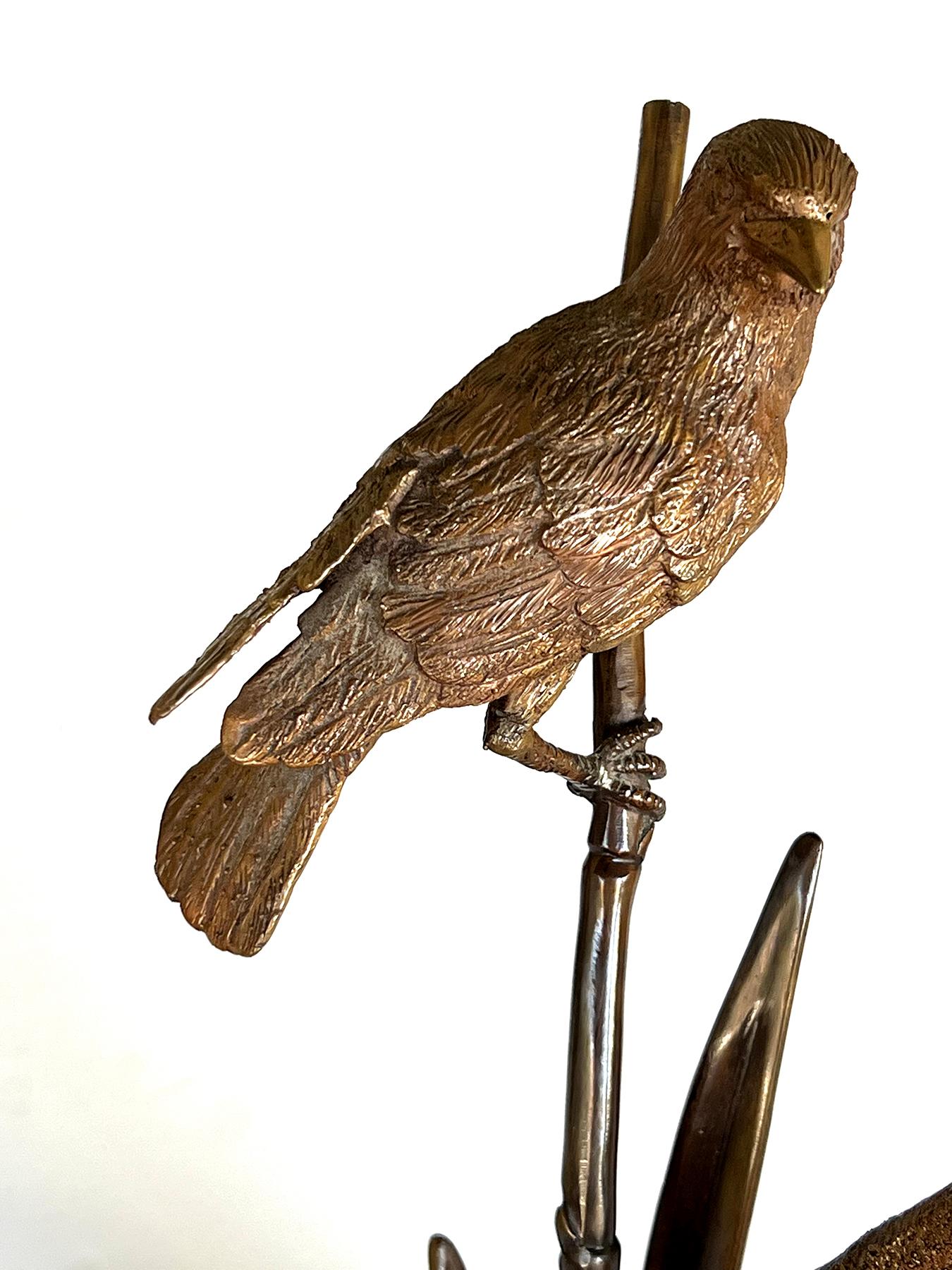 una deliziosa scultura in bronzo raffigurante un passero ben delineato appollaiato su un ramo di bambù circondato da code di gatto e canne che emanano da un anello fogliare; l'insieme poggia su una base circolare di marmo nero ben modellata; firma
