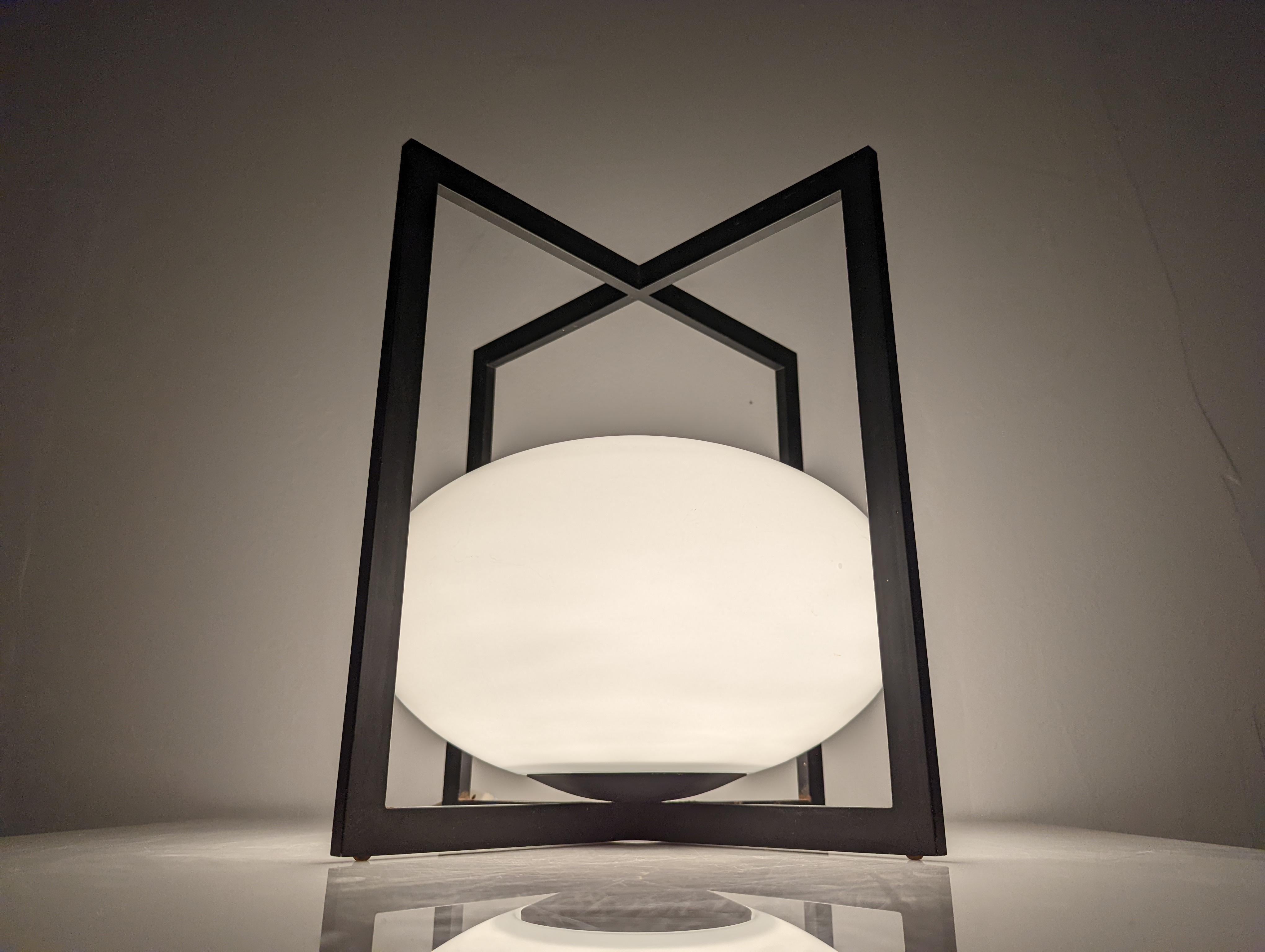 Wonderful vintage lamp from the 70s with a spectacular design in black metal and oval glass. With straight and clean lines, it undoubtedly overflows with the style and talent of a great designer of the time yet to be discovered.
