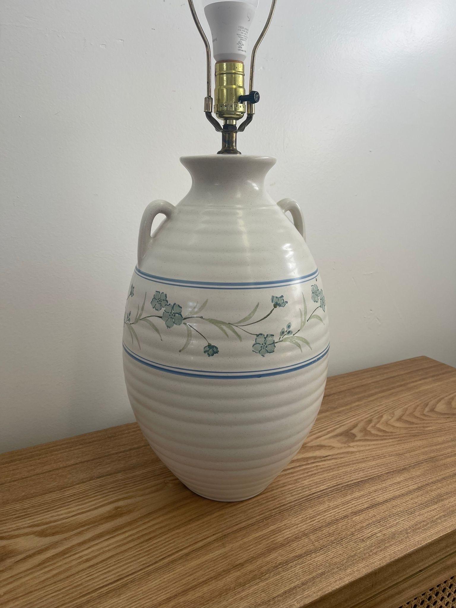 This White toned Ceramic Base has blu and green floral detailing hand painted onto it. Two handles. Light Bulb not Included. Vintage Condition Consistent with Age as Pictured.

Dimensions. 10 Diameter; 27 H