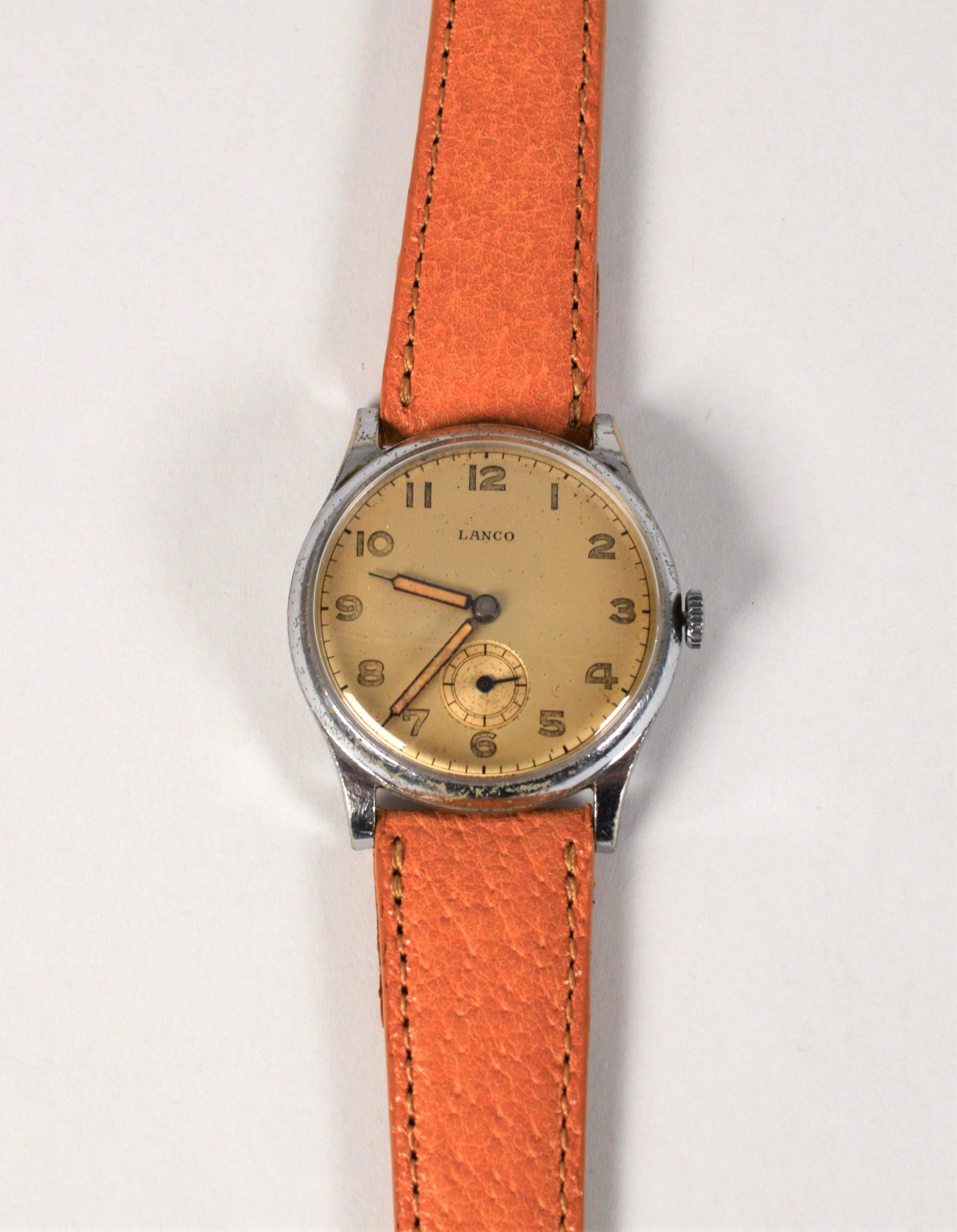 Vintage with character, this Lanco Stainless Steel Wrist Watch is well preserved and was popular with the German Army during WWII. The timepiece features a satin gold-tone face with easy to read Arabic numeral indexes and subsidiary dial.  In size