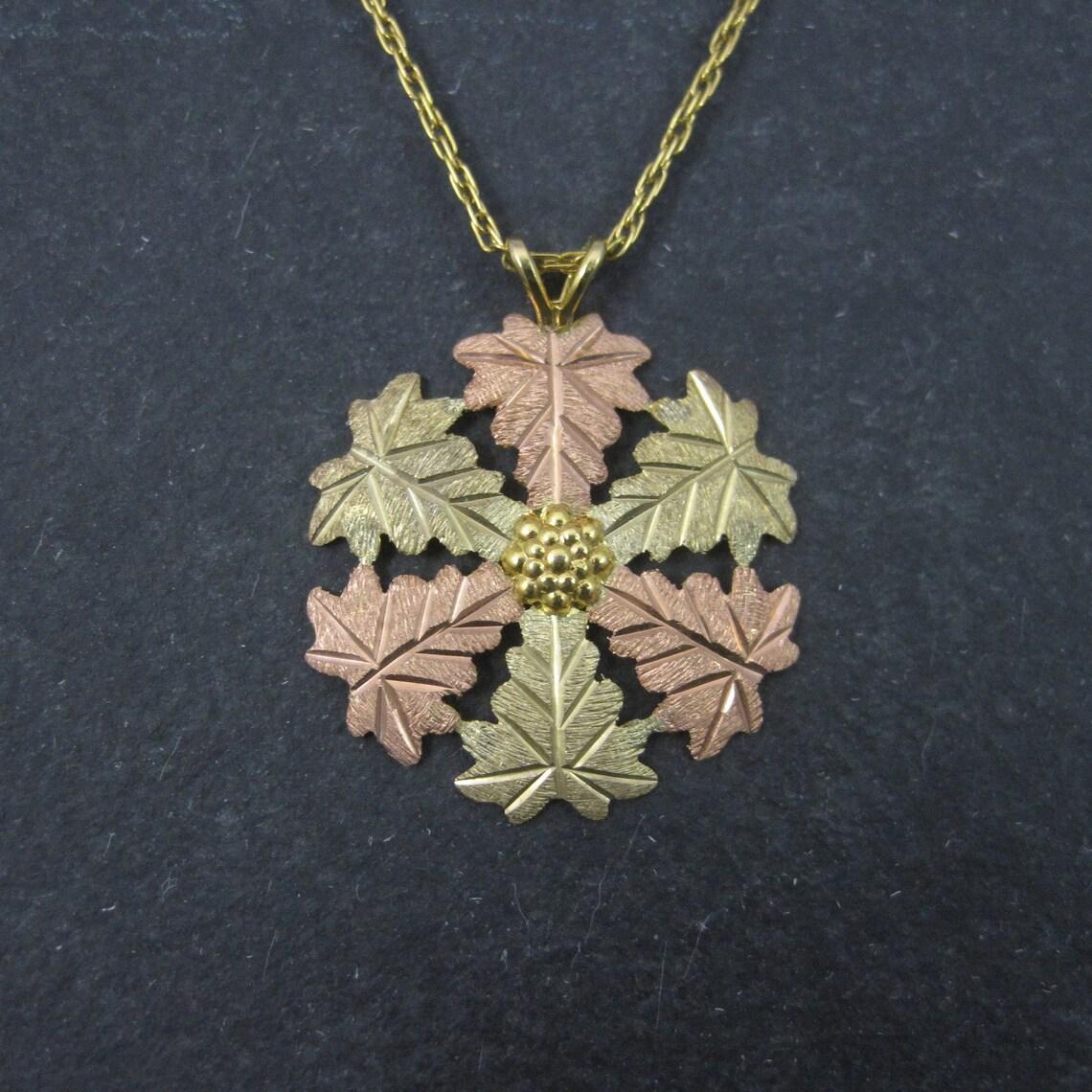 This gorgeous, vintage Black Hills Gold pendant is 10k yellow, pink and green gold.
It is a product of Landstroms.

Measurements: 7/8 by 1 inch
Comes on a 14k gold filled, 18 inch chain

Condition: Excellent - like new