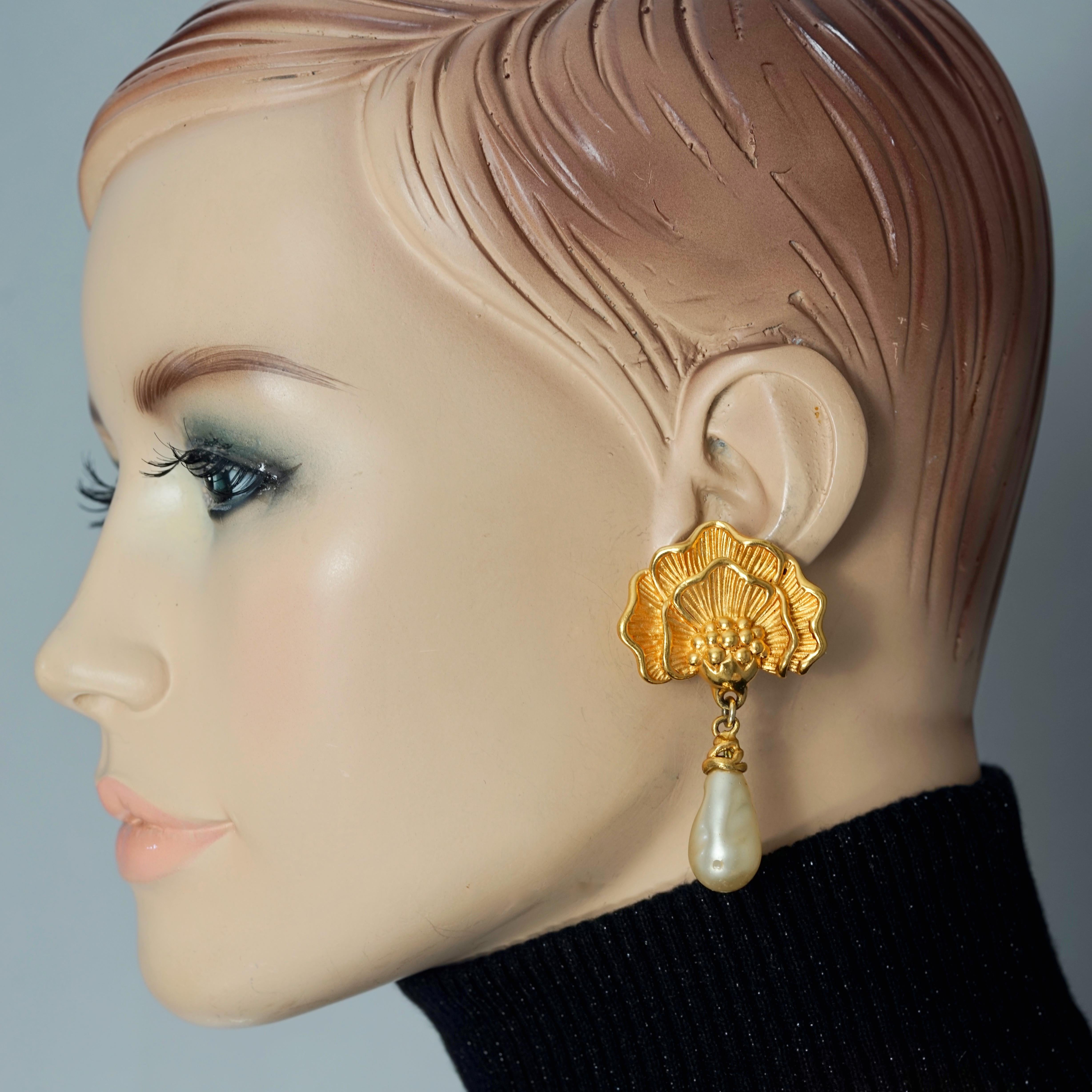 Vintage LANVIN Flower Pearl Drop Earrings

MEASUREMENTS:
Height: 2.44 inches (6.2 cm)
Width: 1.96 inches (5 cm)

Features:
- 100% Authentic LANVIN.
- Dangling earrings flower with glass teardrop pearl.
- Clipback earrings.
- Signed LANVIN GERMANY.
-