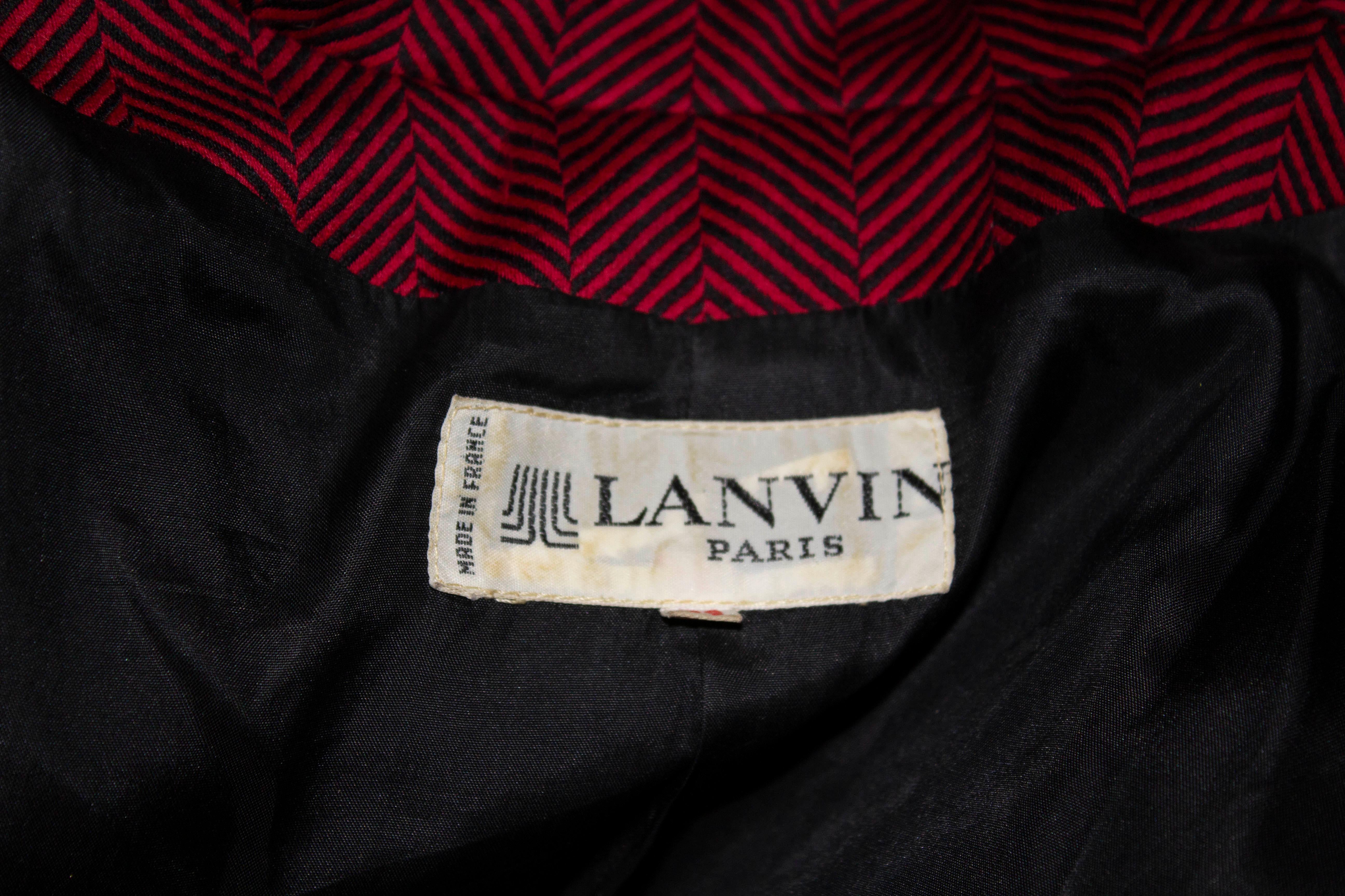 A chic vintage skirt suit by Lanvin Paris, in red and black wool.

The jacket has a cutaway collar, with two pockets at waist leval and two buttons. It is fully lined.
The skirt has an attractive waist band and is fully lined.

Measurements ; Size