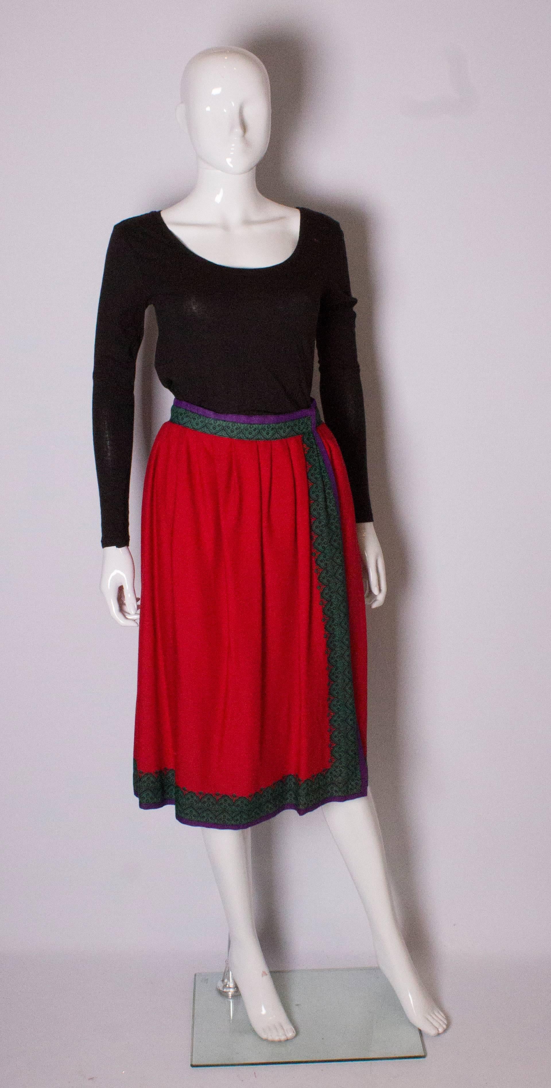 A chic skirt by Lanvin. The skirt is in a red wool with a green and purple border at hem and front. 