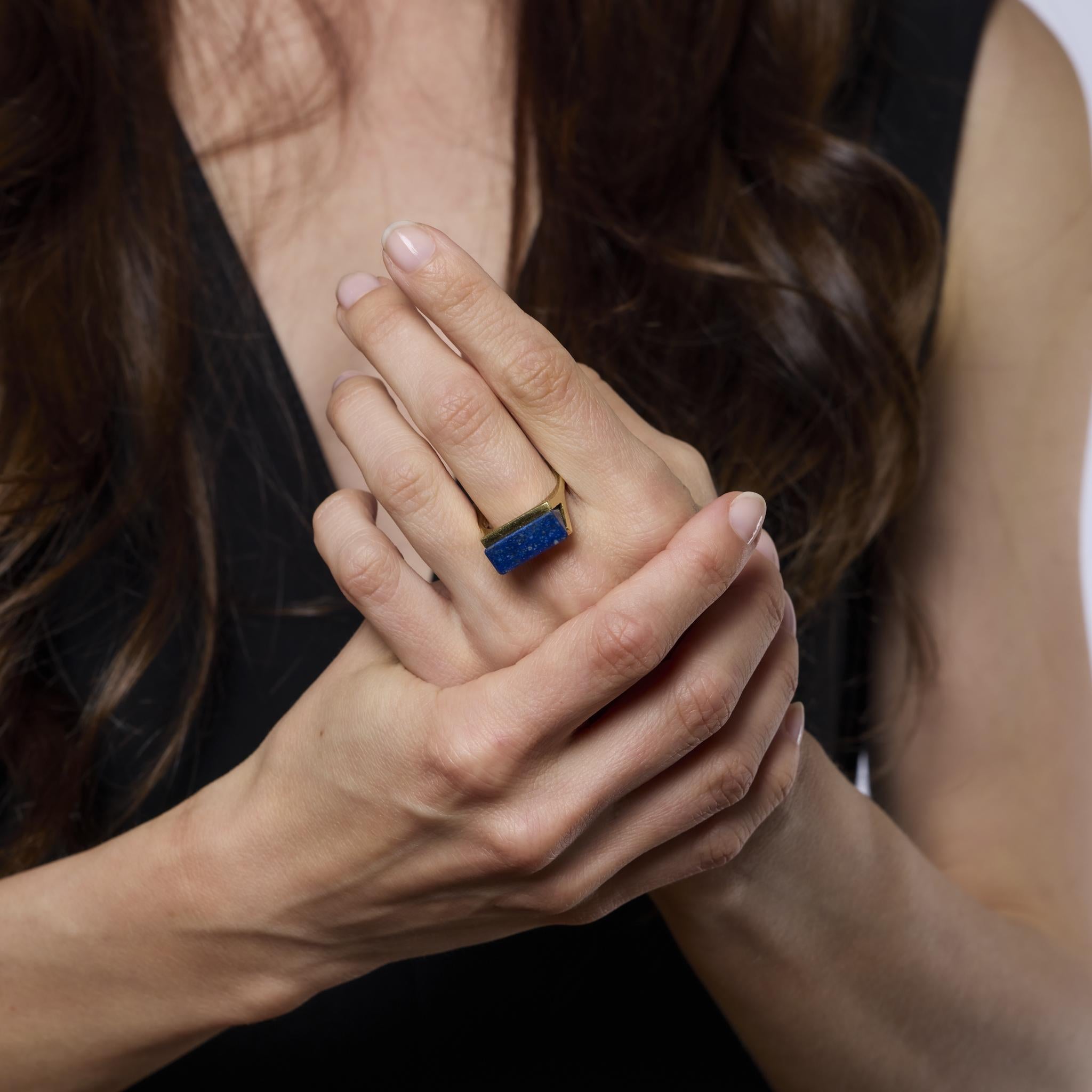 This bold vintage ring features a richly colored lapis lazuli centerpiece set in warm 14k yellow gold. A striking 1970s design that embodies effortless retro elegance and vibrant style.