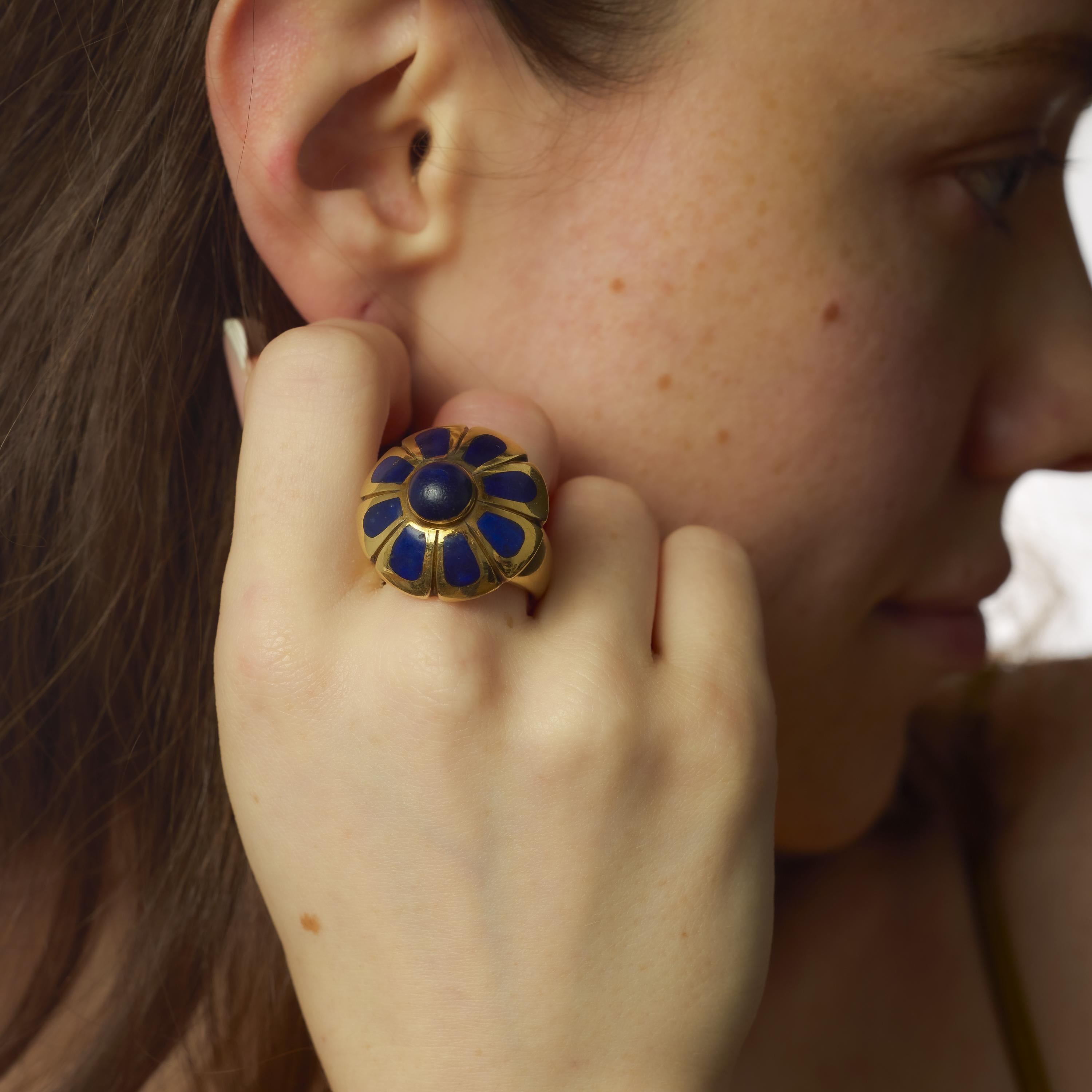 Questo audace anello vintage degli anni '80 è incentrato su un lapislazzuli riccamente colorato, la cui tonalità blu intenso è esaltata dal contrasto lucido dello smalto dettagliato. L'incastonatura è realizzata con una combinazione di oro giallo 18