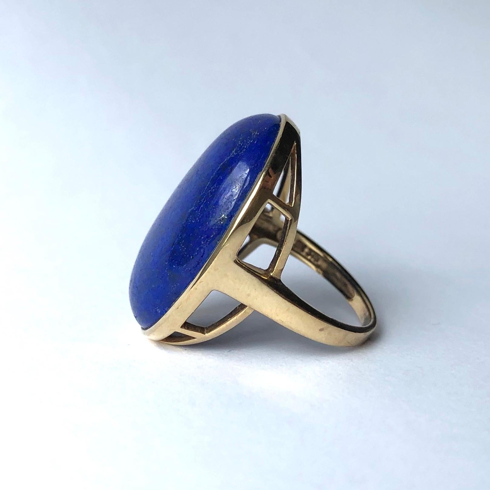 The large face of this ring is made up of a bright blue lapis stone set simply within a 9ct old frame. The ring features an open work gallery which leads to a very simple gold band. 

Ring Size: K or 5 1/4 
Stone Dimensions: 28x24mm
Height From