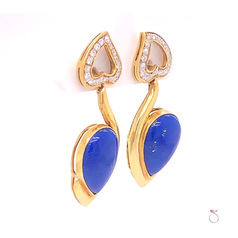 Beautifully Lapis Lazuli diamond dangling earrings in 14k yellow gold. These gorgeous earrings has a deep blue pear shape Lapis cabochons dangling from an inverted heart set with diamonds. The Lapis cabochons are bezel set. Each heart is set with 16