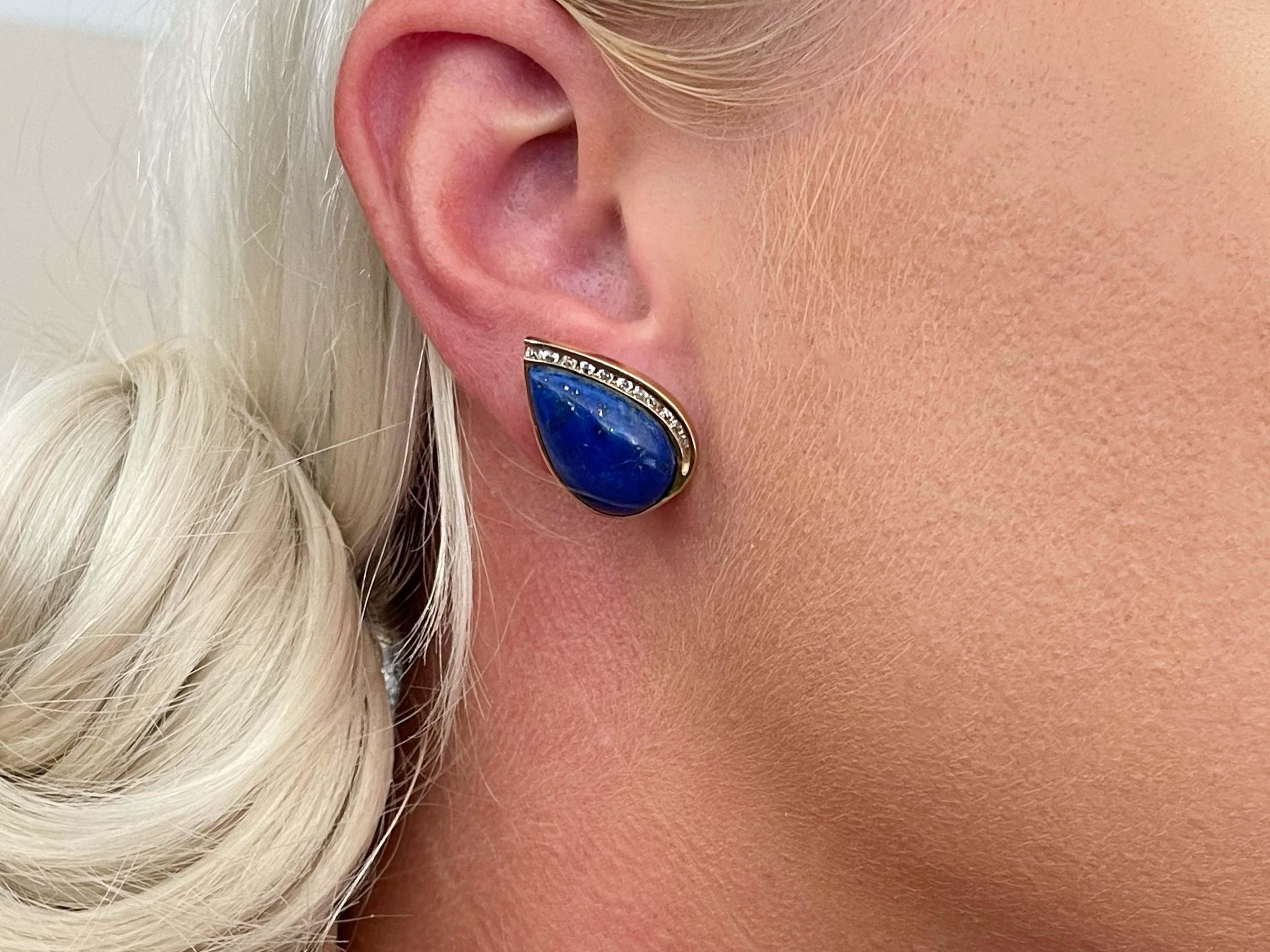 These gorgeous earrings feature a deep blue pear shape Lapis cabochons bezel set. Each side of the earring is set with 11 round brilliant cut diamonds totaling 22 diamonds on the pair. The diamonds are G-I in color and SI1 in clarity. The total