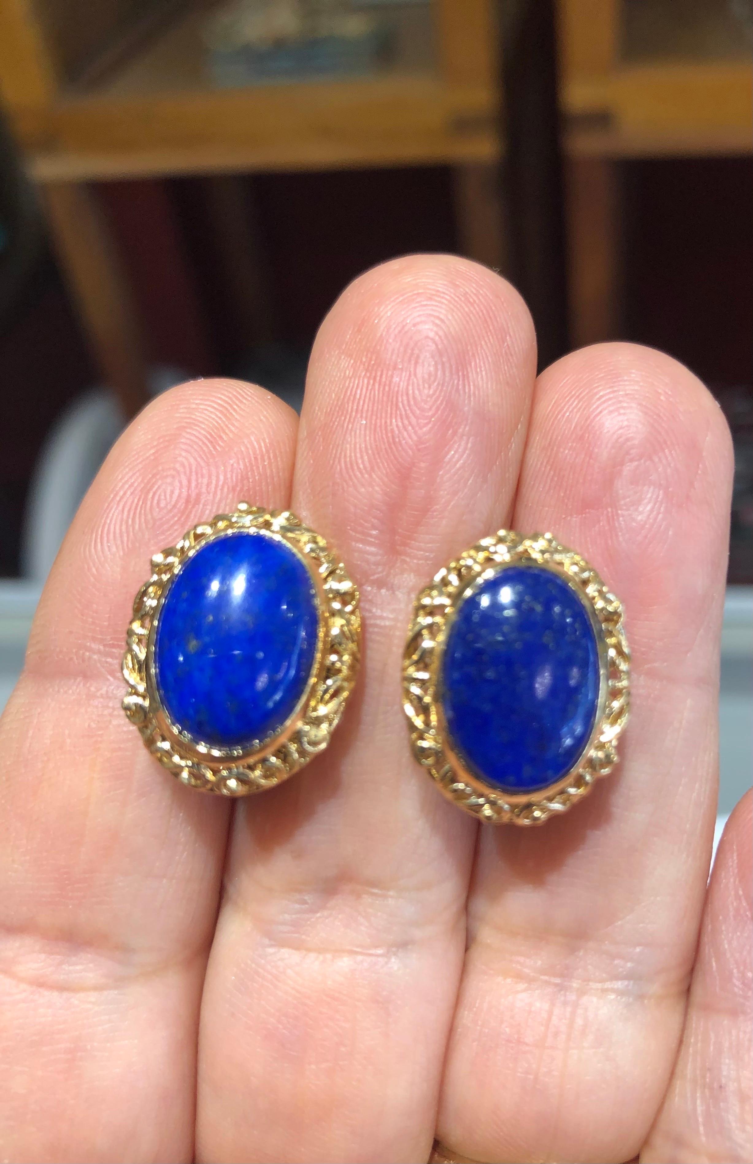 Une élégante paire de boucles d'oreilles en lapis-lazuli de collection, présentant un superbe motif de volutes en or jaune 18 carats. Elles sont serties de deux pierres ovales en lapis-lazuli mesurant 14 mm x 10 mm et pesant 9,6 grammes.
Vers les