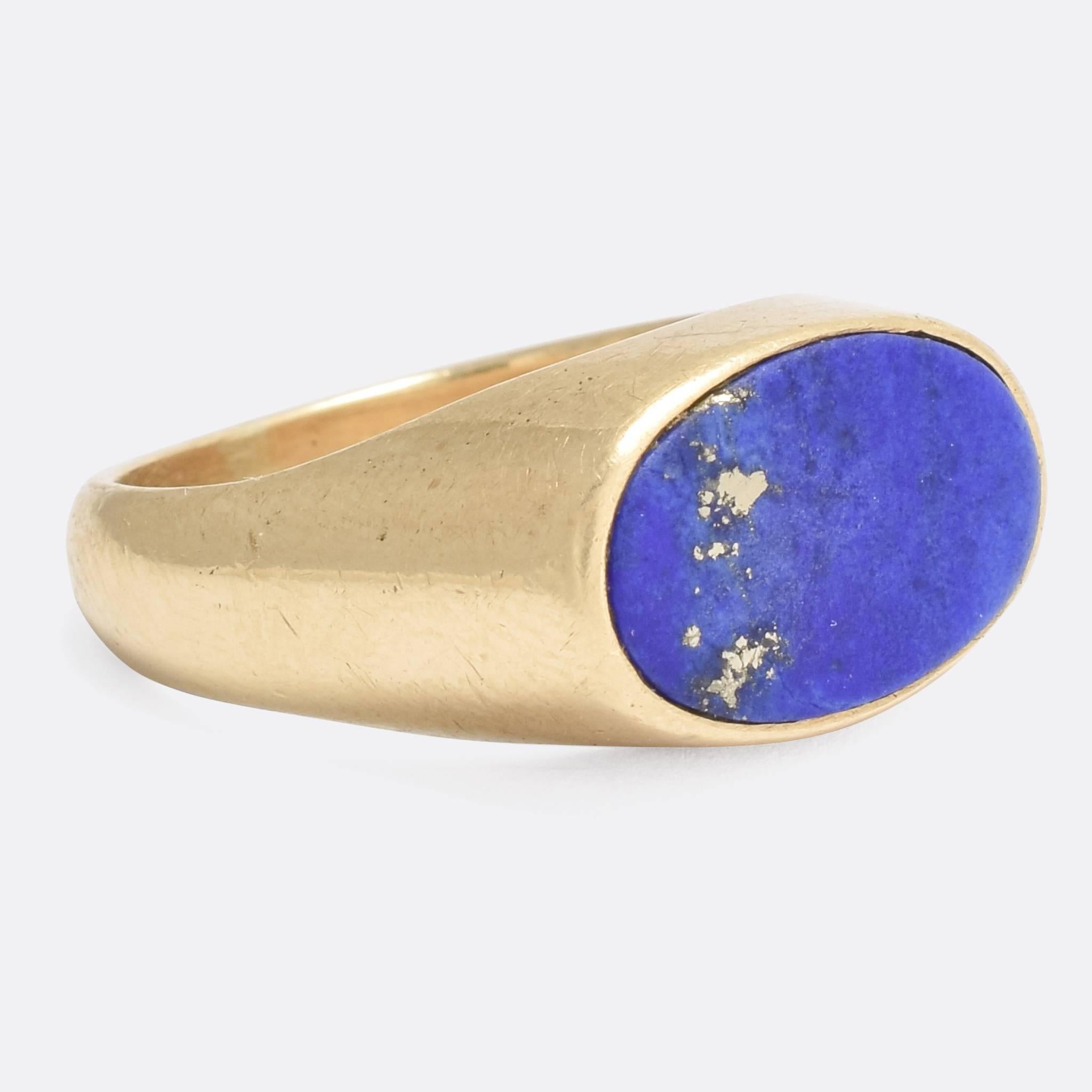 A cool vintage signet ring, that echoes the modernist styles of the mid-20th Century. It's set with an oval Lapis lazuli panel, a beautiful contrast to the yellow gold of the mount. Modelled in 9k gold throughout, with clear London hallmarks dating