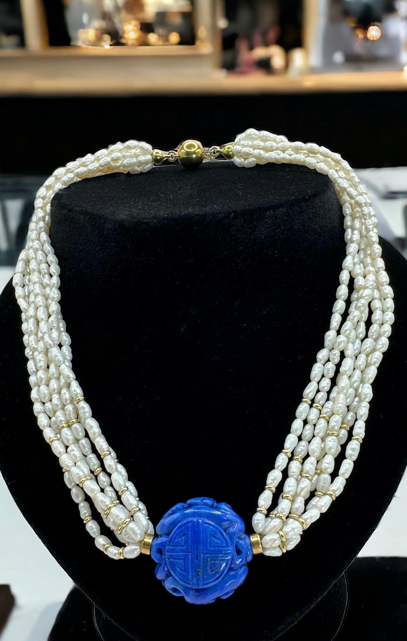 Unveil the splendor of yesteryears with this vintage necklace, strung with delicate freshwater rice pearls. 

This piece weighs 53.2 grams and spans 40 cm, culminating in a majestic, carved lapis lazuli centerpiece. 

The necklace is interspersed