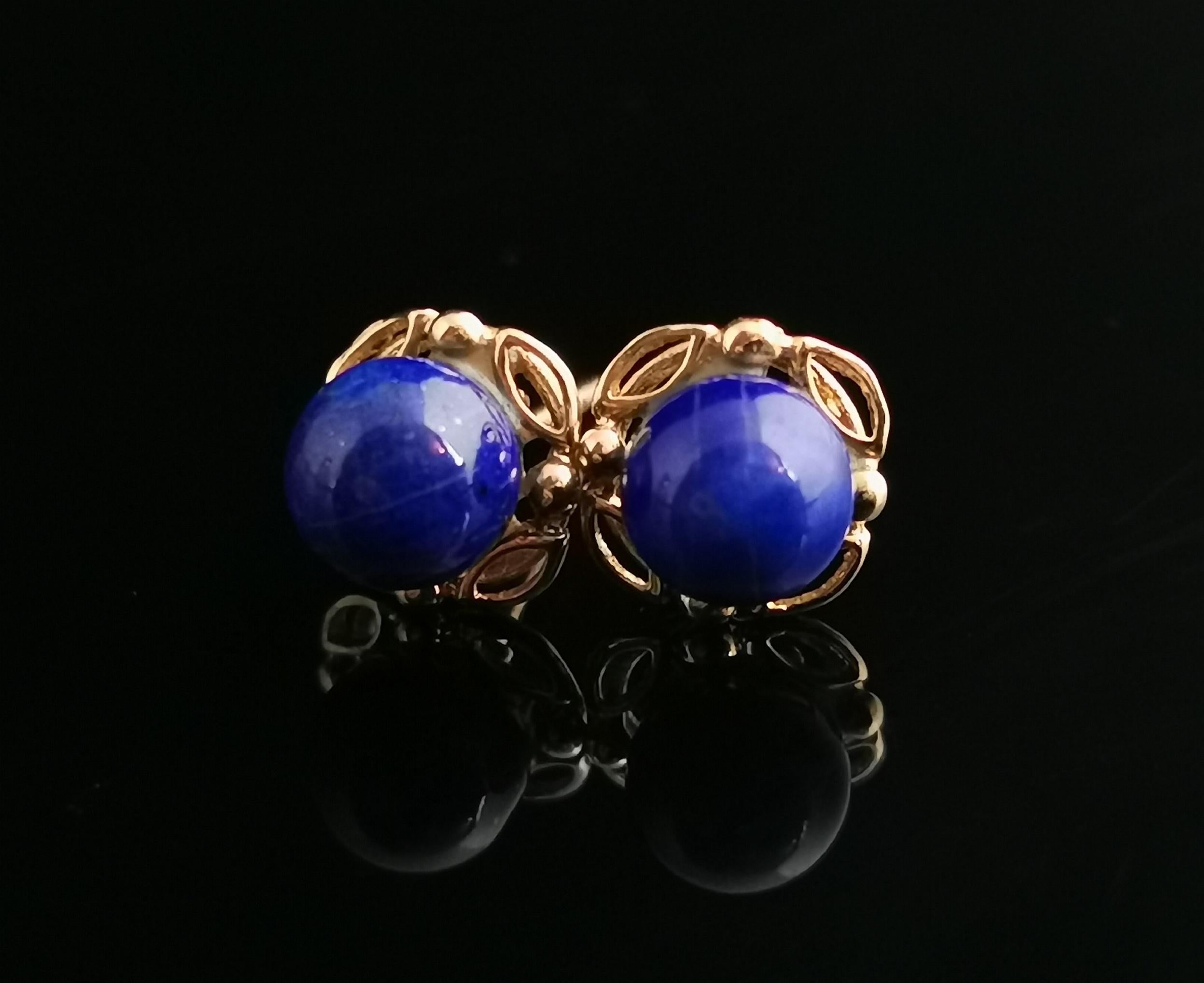 A very pretty pair of vintage Lapis Lazuli and 9kt yellow gold stud earrings.

Sweet button bead lapis lazuli cabochons set onto a fancy 9kt yellow gold scrolling mount with 9kt gold Post backs.

They come with a replacement pair of vintage gold