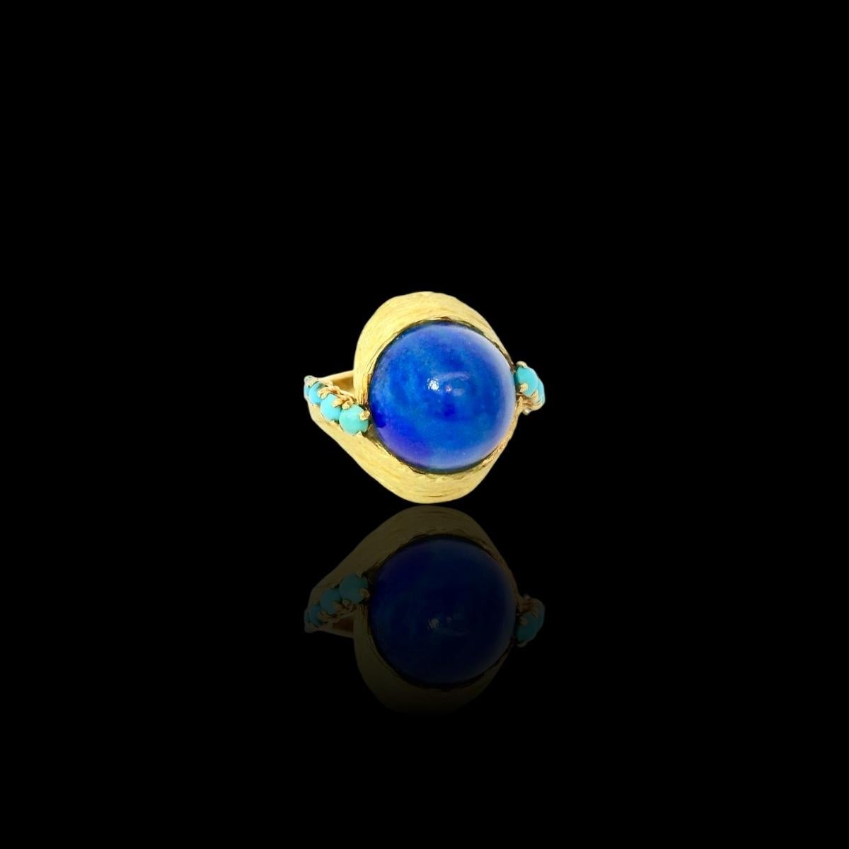 Anello vintage in oro giallo 18 carati. 

L'anello è incastonato con un Lapiz Lazuli cabochon e 8 turchesi. 

Peso dell'anello: 12,5 grammi 

Altezza dell'anello: 1,7 cm 

L'anello è molto speciale. 

All'interno dell'anello è presente una firma. 