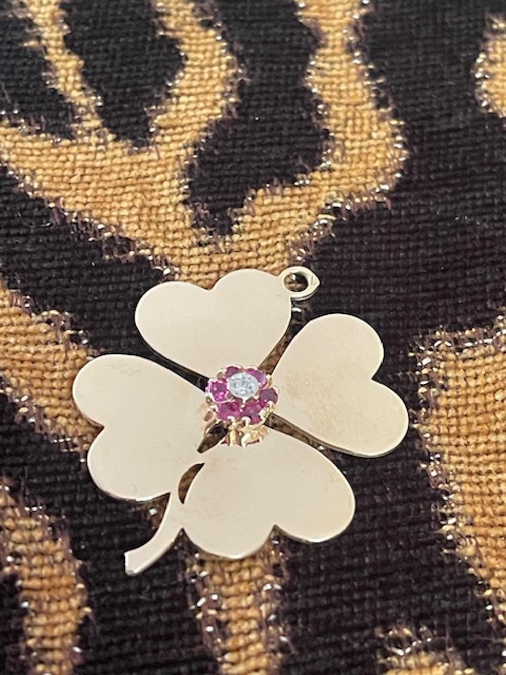 This fabulous 14k yellow gold statement size large clover charm is set with a raised cluster of rubies surrounding a further raised prong set diamond. 
This is a fabulous vintage estate piece that is in excellent unworn condition. 

Heart clovers