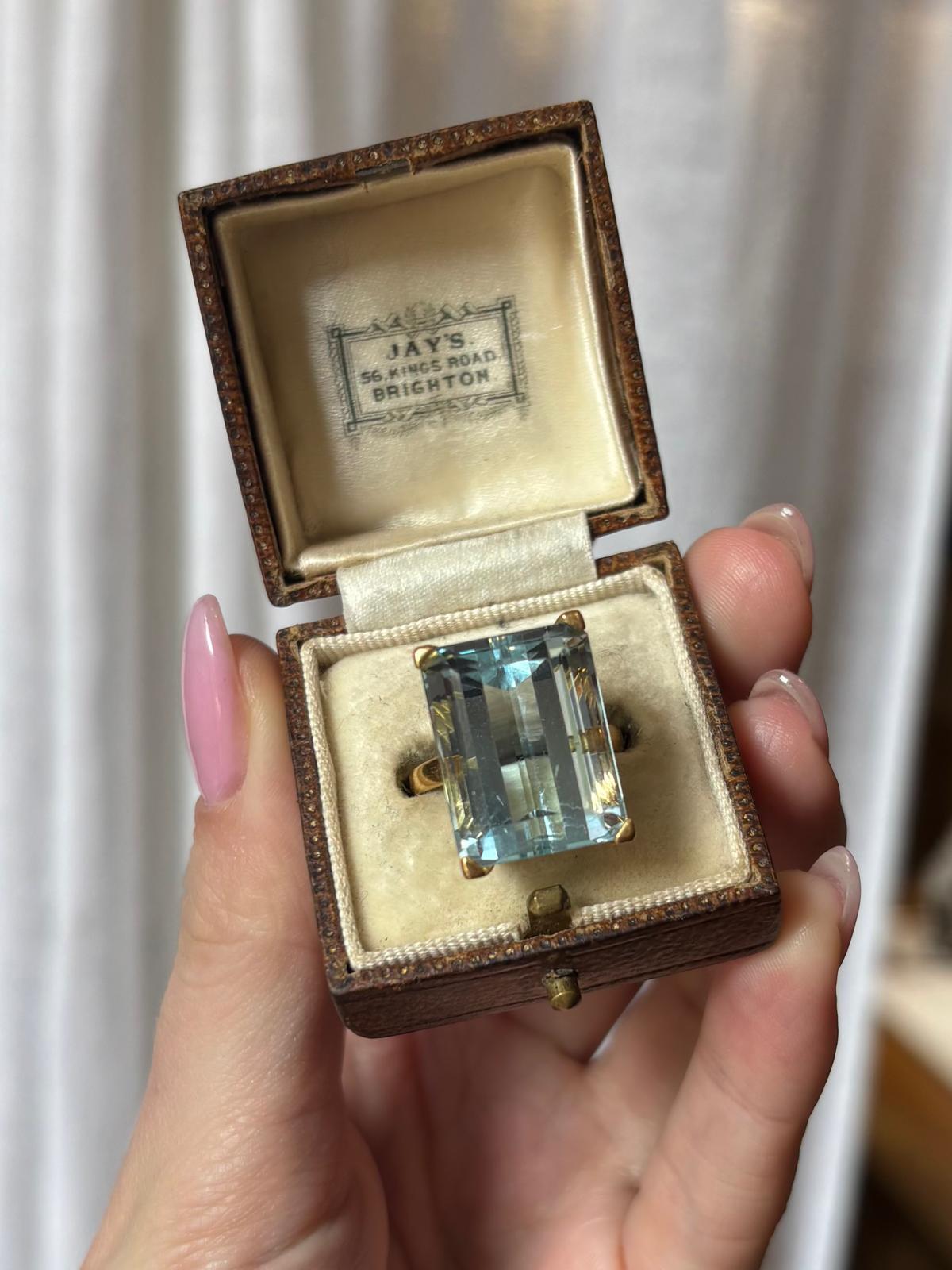 A marvellous vintage aquamarine cocktail ring set in 18k yellow gold. 

The ring is solely set with a beautiful sky blue coloured emerald cut aquamarine stone. The aquamarine is four claw open setting which allows the light to reflect through the