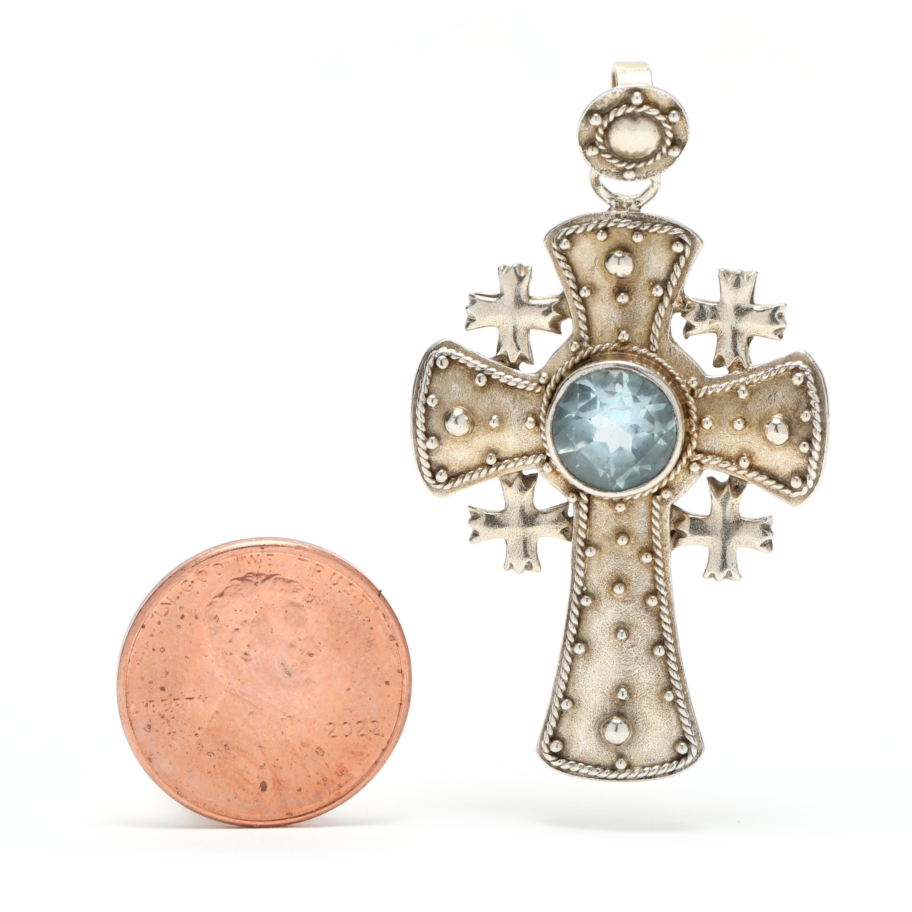 This stunning vintage cross pendant is made from sterling silver and features a large 2.5ct blue topaz gemstone. The beaded design of the cross is eye-catching and the length of the pendant is 1.75 inches. This beautiful pendant is perfect for