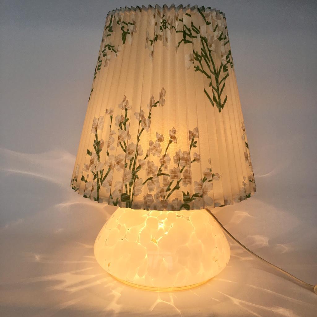 This lamp has two light bulbs one in the shade and one in the glass base. Original cotton/plastic shade.