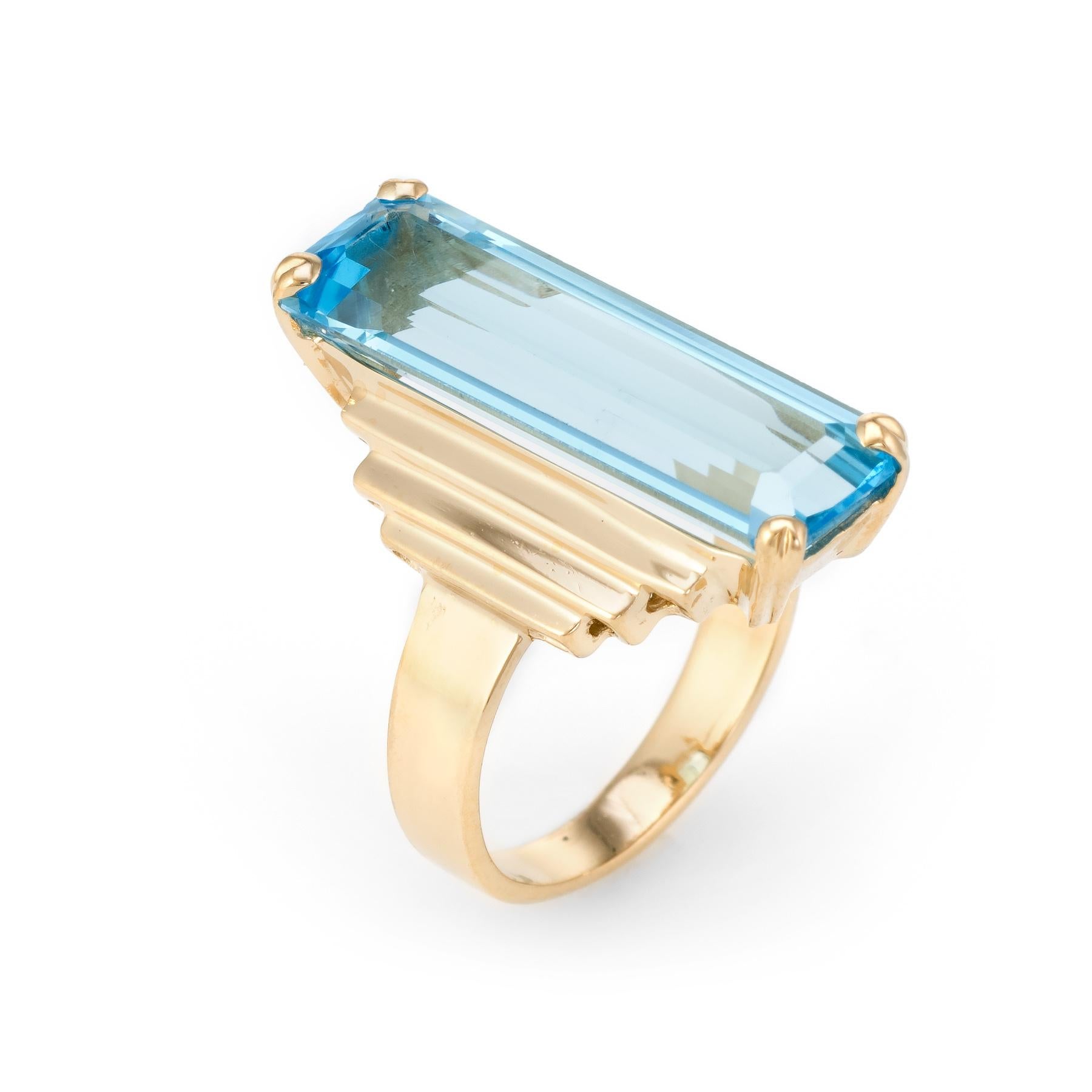 Finely detailed vintage cocktail ring (circa 1960s to 1970s), crafted in 14 karat yellow gold. 

Large emerald cut blue topaz measures 25mm x 8mm (estimated at 15 carats). The topaz is in excellent condition and free of cracks or chips. 

Bold and