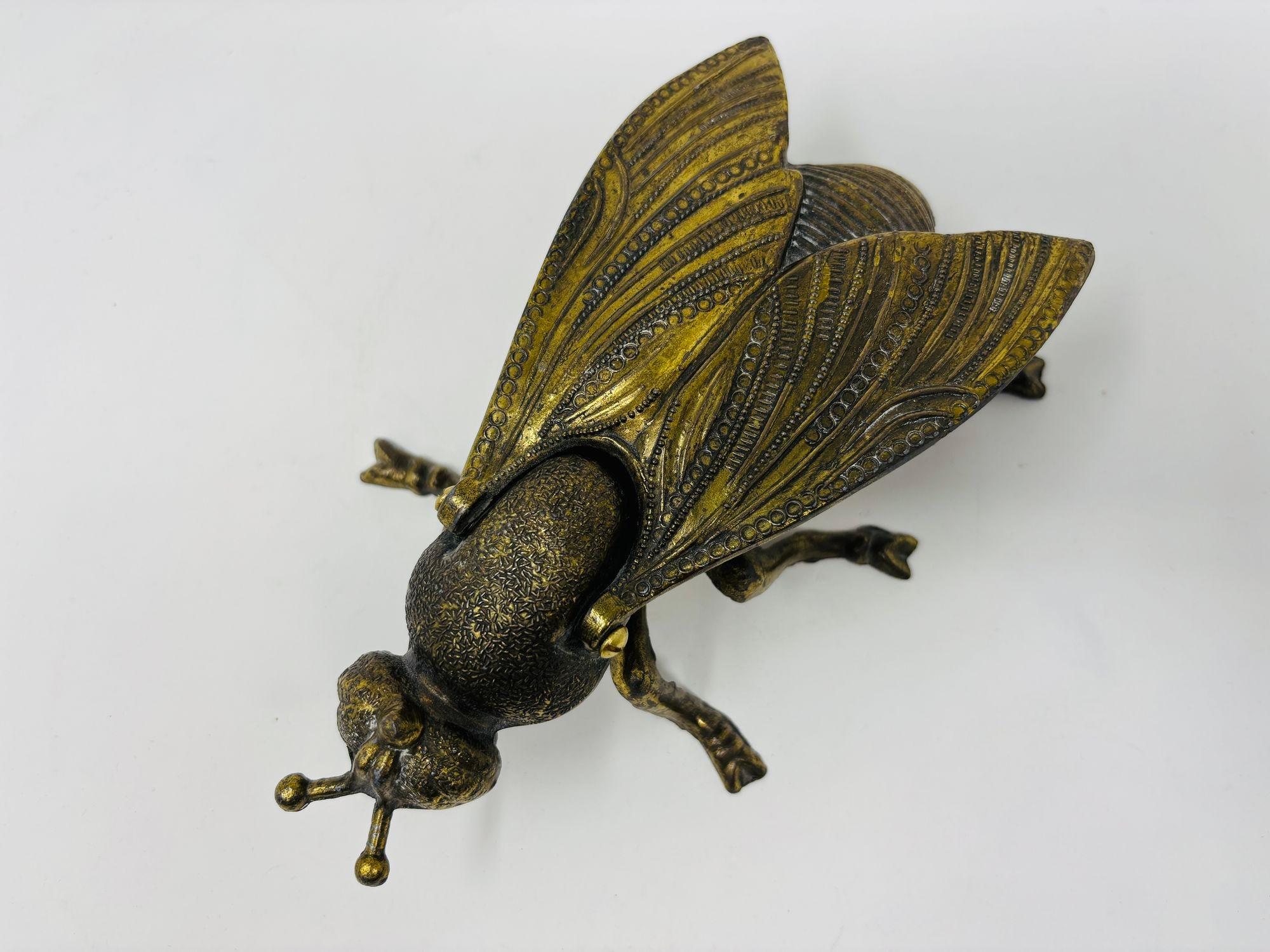 Aggiungi un tocco di fascino moderno di metà secolo alla tua collezione con questo posacenere scultoreo vintage in ottone.
Questa statuetta di mosca in metallo di grandi dimensioni funge sia da posacenere funzionale che da pezzo decorativo unico nel