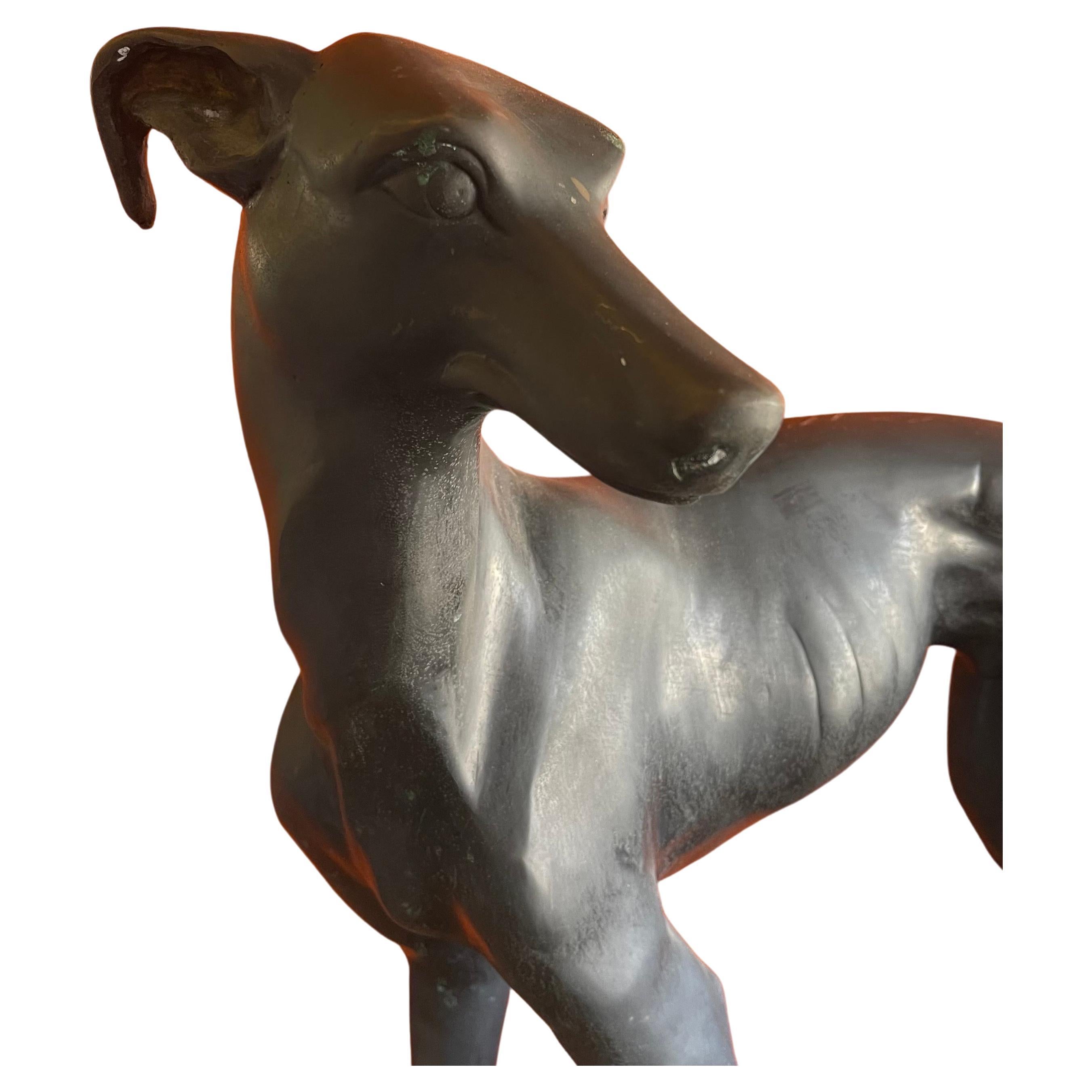 A well detailed and patinated vintage bronze greyhound sculpture, circa 1970s. The piece is in very good vintage condition and quite large: it measures 25