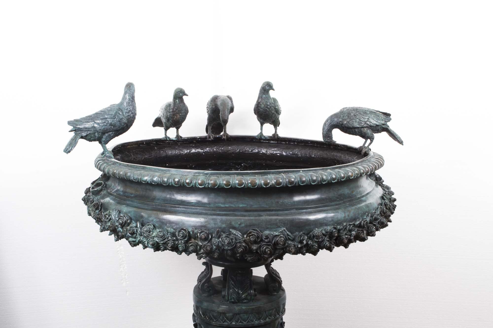 This stunning large vintage fountain bird bath is sculpted in solid bronze in the classical Greek Style and dates from the late 20th century.

The fountain features a large urn with exquisite decoration on a cylindrical plinth decorated with