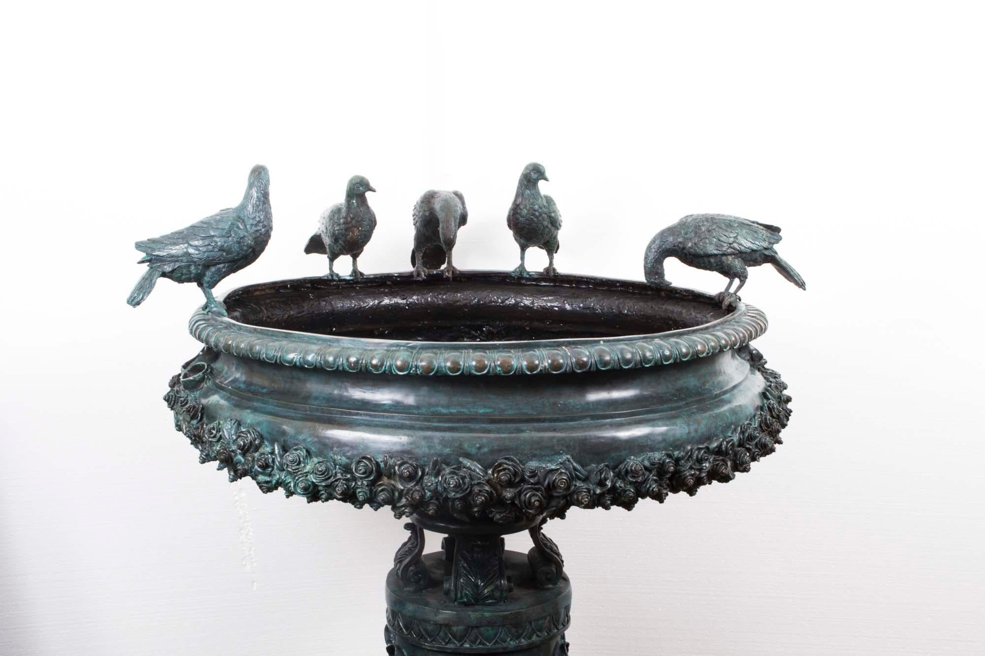 This stunning large vintage fountain bird bath is sculpted in solid bronze in the classical Greek Style and dates from the late 20th Century.

The fountain features a large urn with exquisite decoration on a cylindrical plinth decorated with laurels