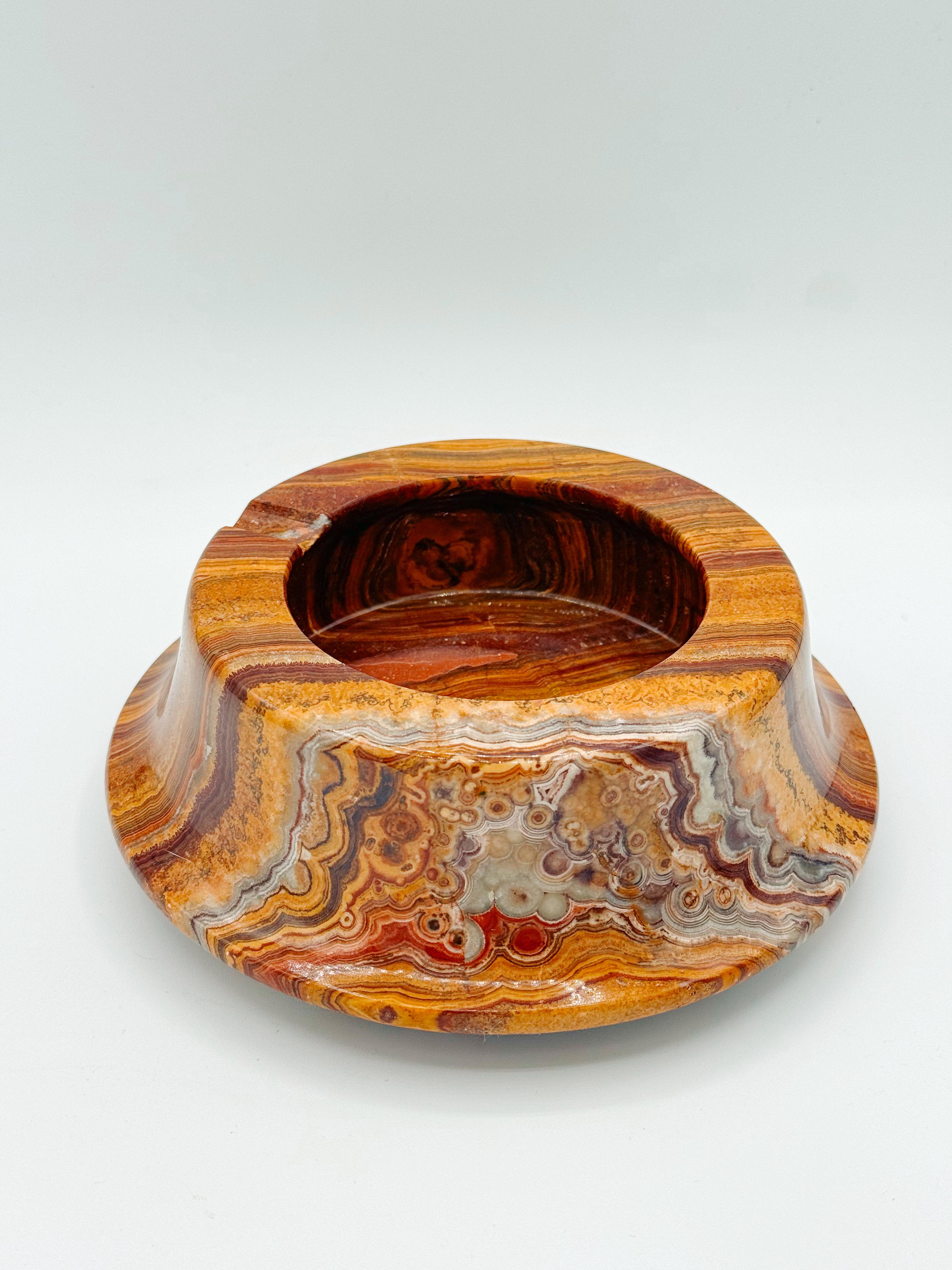 Este cenicero vintage de ónice marrón de mediados de siglo es un asombroso ejemplo de diseño atemporal, con un precioso dibujo burilado con remolinos de tonos marrones, crema y rojos. Su superficie pulida resalta el intrincado veteado natural,
