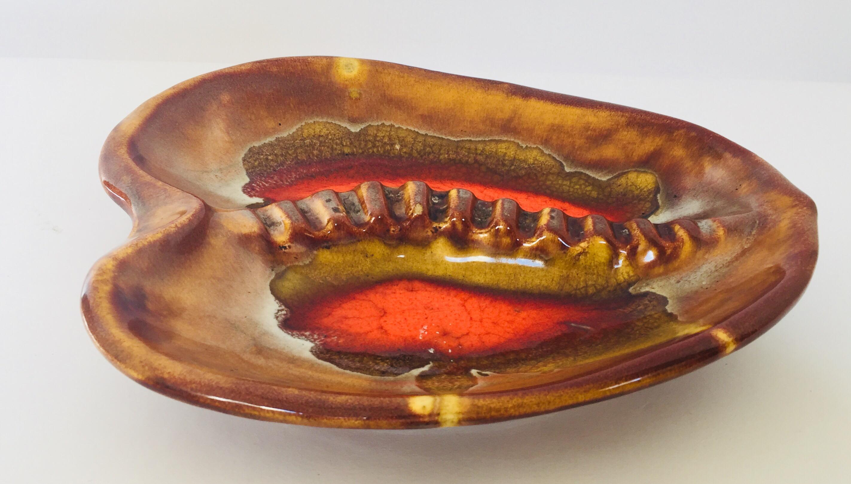 California Pottery, large vintage ceramic ashtray in retro bright orange, red, browns and yellow flamed colors.
Kidney shape made in California USA.