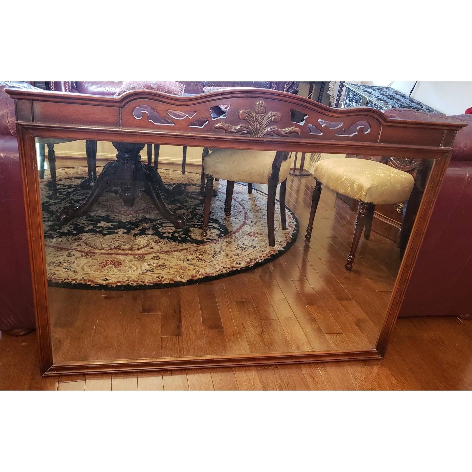 Vintage solid Mahogany wall mirror. Clean carvings on top frame. Lean mahogany frame. Vintage mirror show some signs of aging. Measures 49.5 W x 1.5 D x 37.5 H.
    