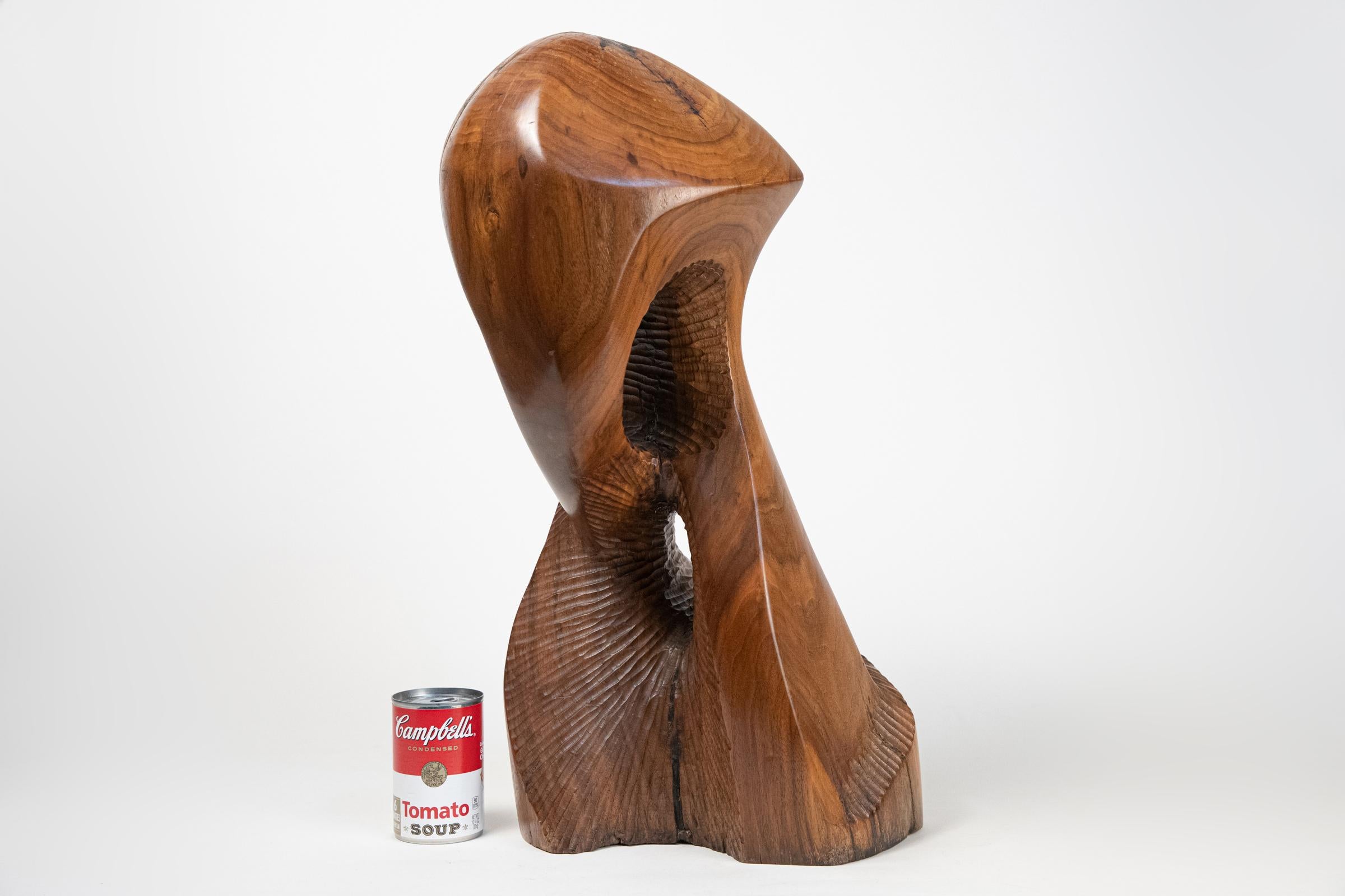Large carved solid wood abstract sculpture. Unknown artist. Unsigned. Most likely dating to the 1960s. Expertly crafted. Dark colored areas are artist applied wood filler in the wood's natural cracks and gaps. Weighs approximately 25 pounds.