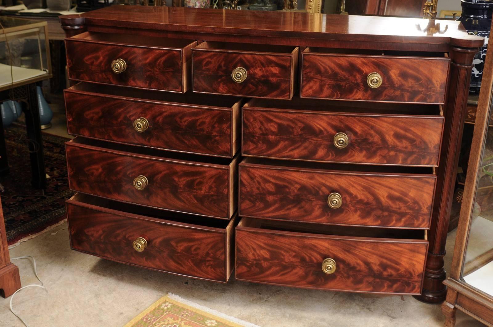 An outstanding chest with a lot of storage in the three small drawers over six large drawers which are flame mahogany with round ring handled brass hardware.
The rectangular top with rounded projecting corners in the front is supported by two