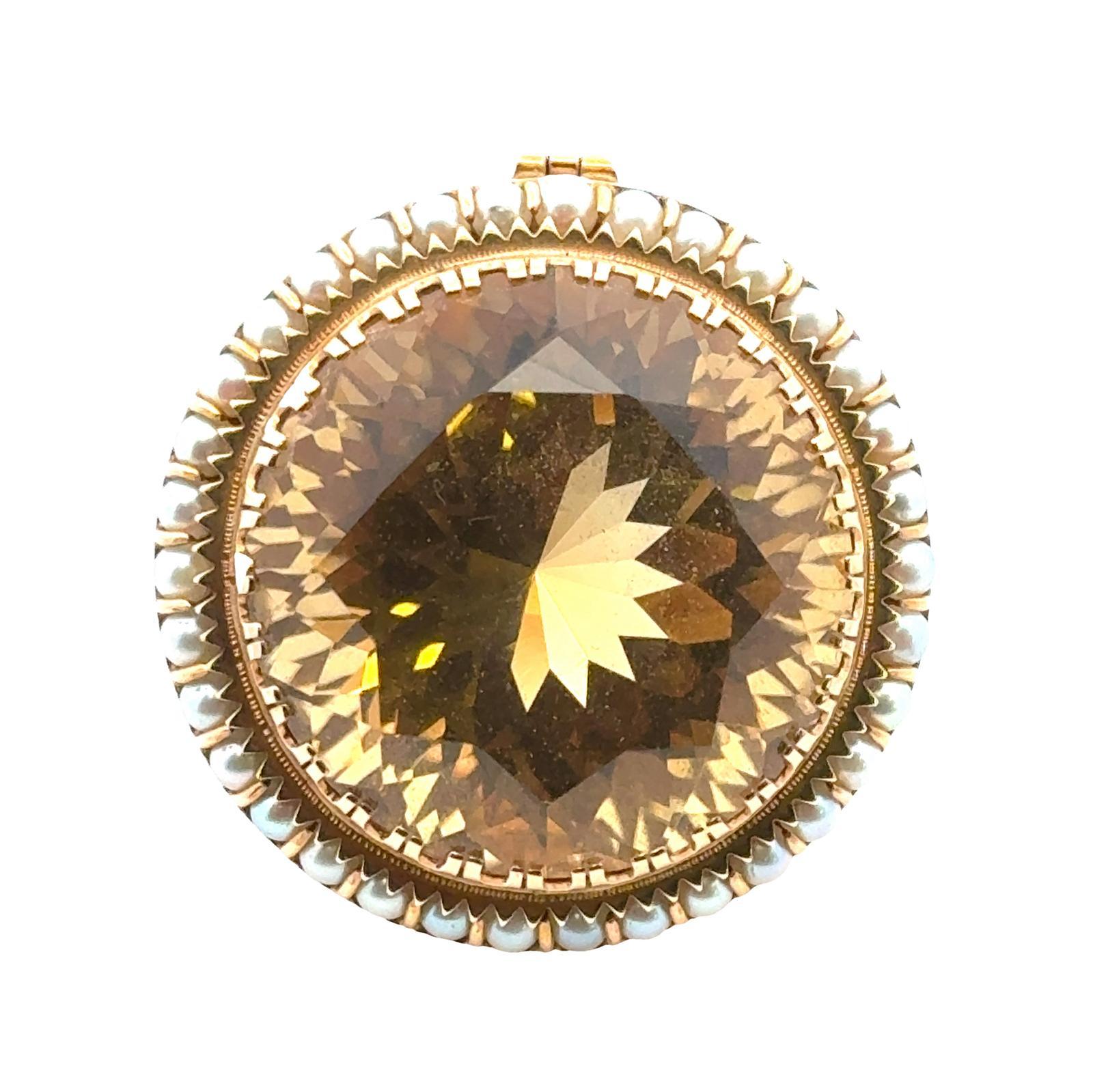 The centerpiece of the brooch is a magnificant round faceted ctirine gemstone radiating with a warm golden hue that captures the eye and adds a touch of sunshine to any ensemble. Surrounding the citrine is a delicate halo of lustrous white seed