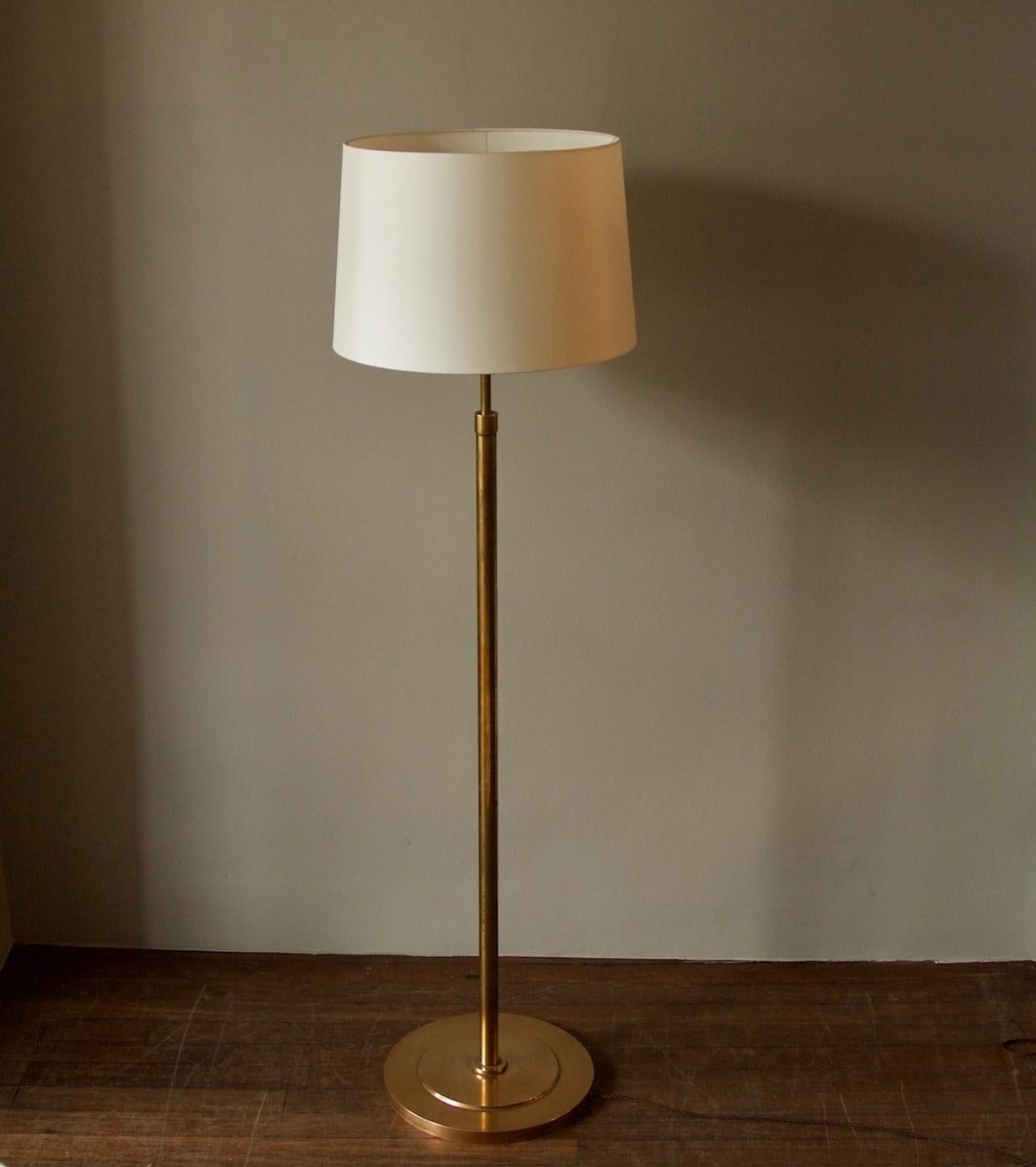 A vintage telescopic floor lamp in brass designed and made in Denmark, circa 1950.
The light, complete with shade, at its tallest measures 183 cm. By pulling downwards, the height of the lamp can be reduced to 157 cm.
The base is circular in shape