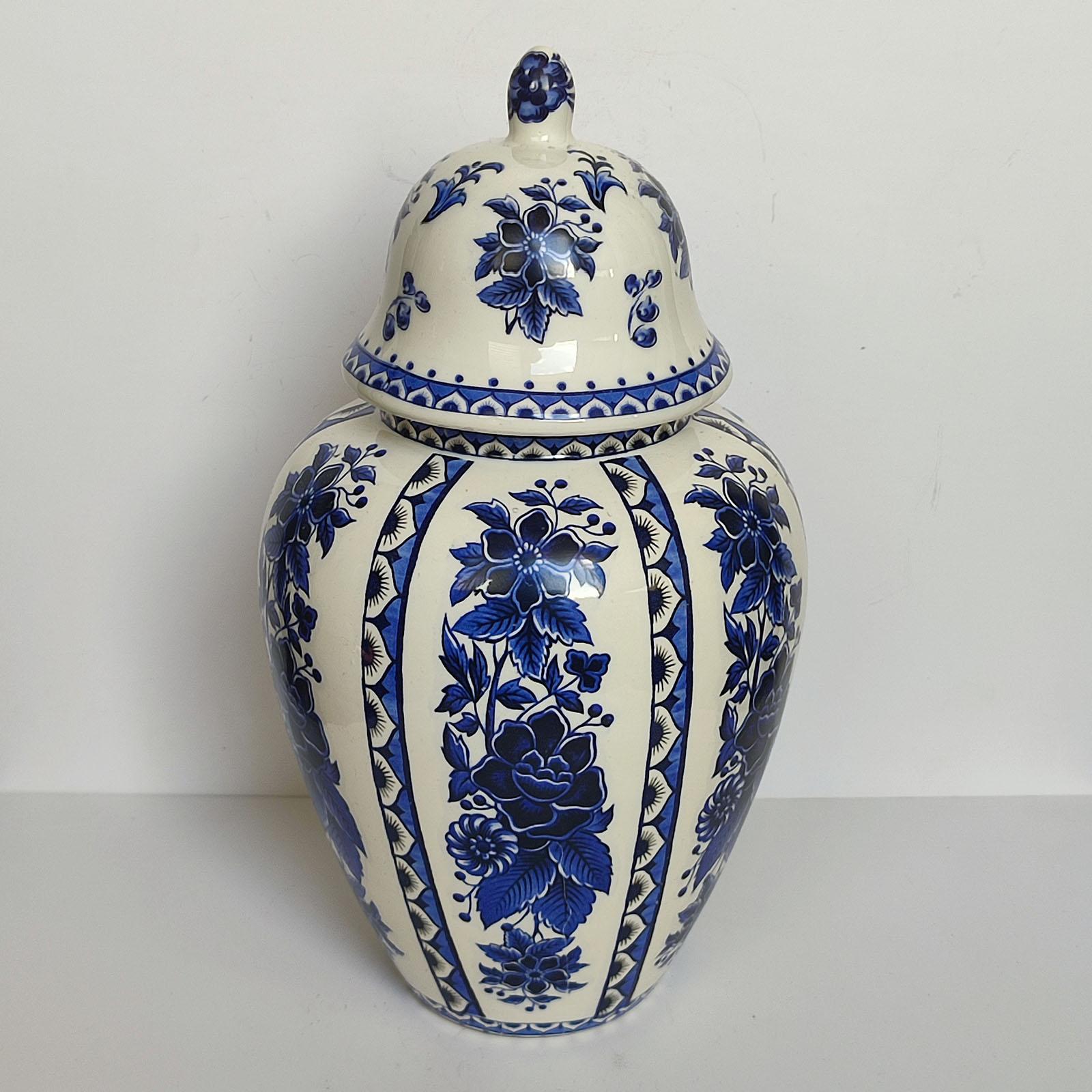 Grande vaso Delft vintage con coperchio, metà del secolo scorso, smalto bianco con decorazioni blu.
Vaso coperto in ceramica con smalto bianco e decorazioni floreali blu. 
Con il marchio Delft sotto il fondo.
Altezza 36 cm [14.2 in].
