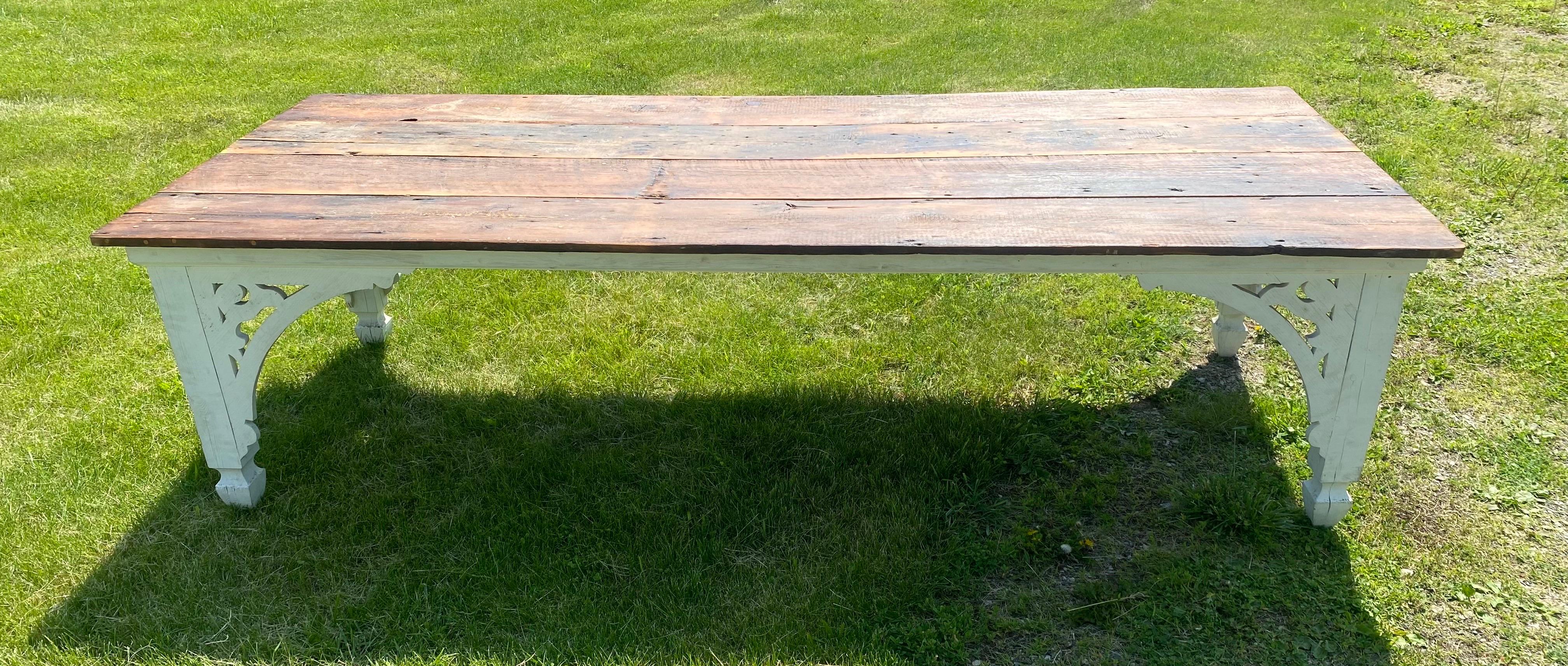 This is a vintage large French country farmhouse style dining table. This rustic table has been made with old floor boarding to give it that rustic antique style. The legs have been white washed and have beautifully executed cut out continental