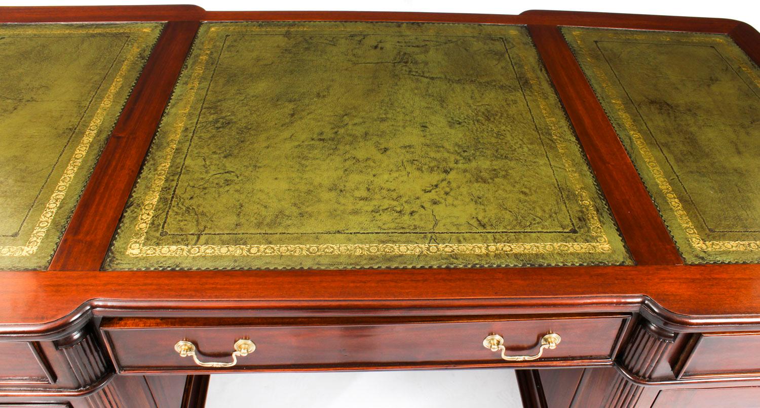 This is a stunning large vintage Georgian style partner’s desk, masterfully crafted in flame mahogany, dating from the second half of the 20th century.

The desk top is of breakfront outline and is fiited with a beautiful inset three part gilt