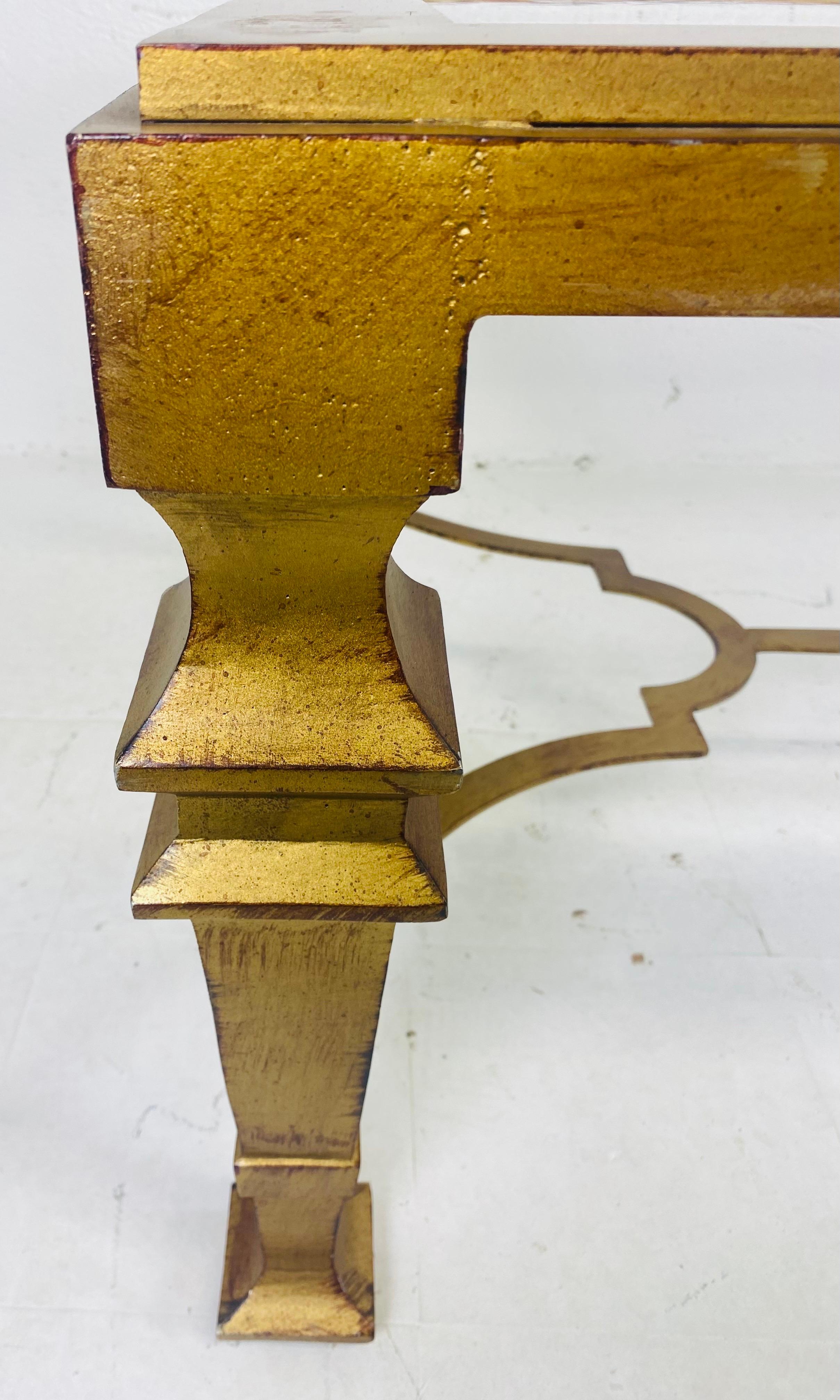 Voici une table basse vintage en fer forgé doré d'inspiration géorgienne. Cette table basse de style néoclassique est dotée d'un plateau en verre soufflé à la main avec un effet d'ondulation. La table basse, de forme néoclassique, a été