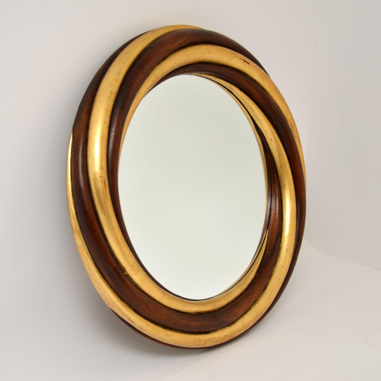 A large and stunning vintage circular wall mirror, this was made by the high end manufacturer Harrison & Gil. It was made in the USA and dates from circa 1980s.

The quality is incredible, the solid mahogany and gilt wood frame is beautifully
