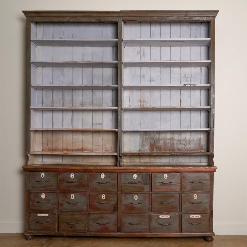 At 8' wide and 9 1/2' tall, this pharmacy apothecary will make an impressive bookcase. Drawer numbers and a few name plates still remain on some of the drawers which add to the vintage character of this large wall unit. Please see the close up
