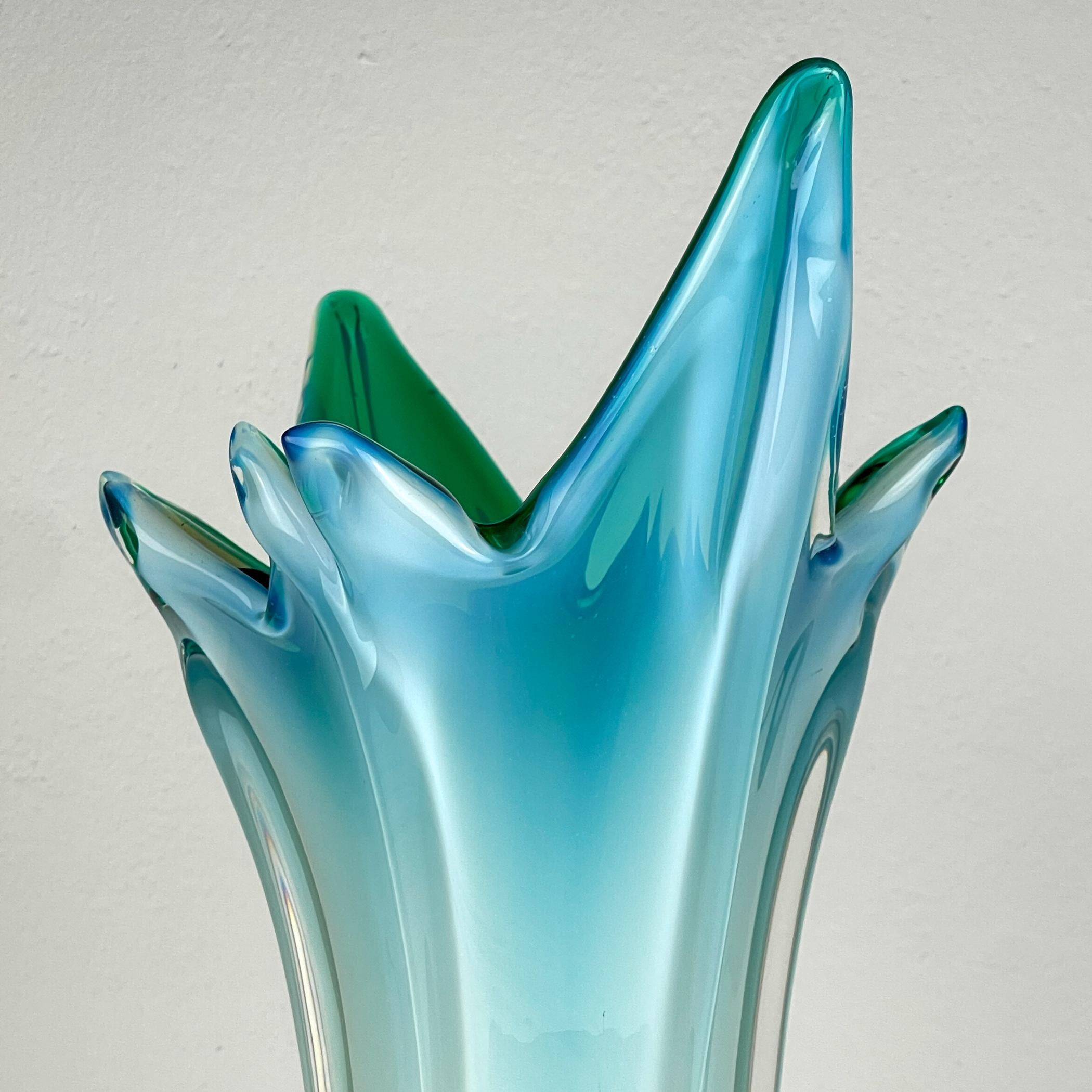 Vaso vintage verde-blu di Murano prodotto in Italia negli anni '70.

È molto ben conservato e rappresenta la patina che ci si aspetta da un oggetto in vetro di oltre 50 anni.

Dimensioni:
Larghezza: 28 cm
Altezza: 52 cm
Profondità: 19 cm / 7,5