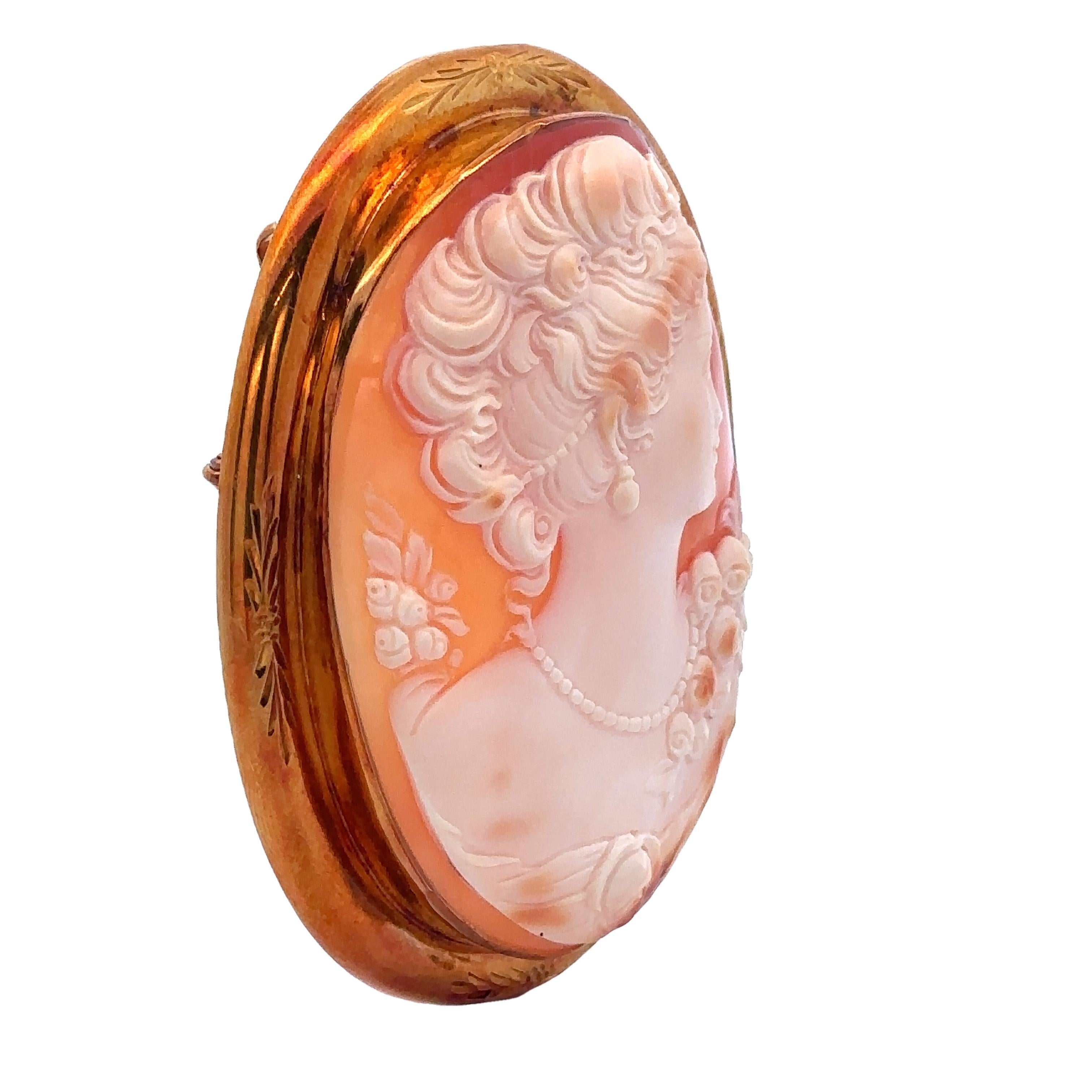 –Stone(s)–
Natural Genuine Shell - Carved Cameo - Medium Orange Color w/ Cream Carving  - 63.61 x 47.93mm (approx.)

Material: 18k Yellow Gold
Weight: 34.21 Grams
Overall Width: 60mm (2.36